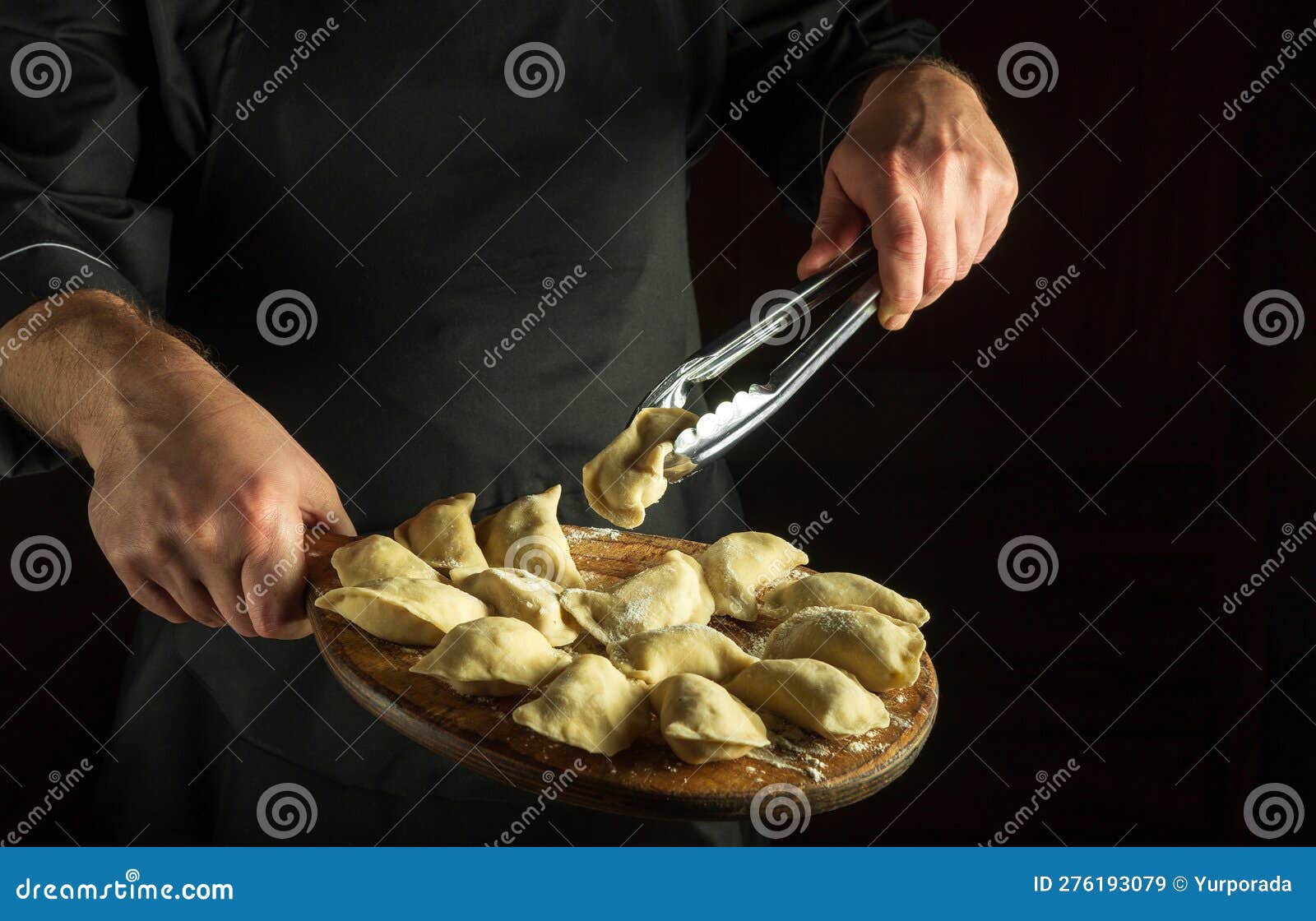 The Cook Takes and Flips the Raw Dumpling with a Culinary Tool