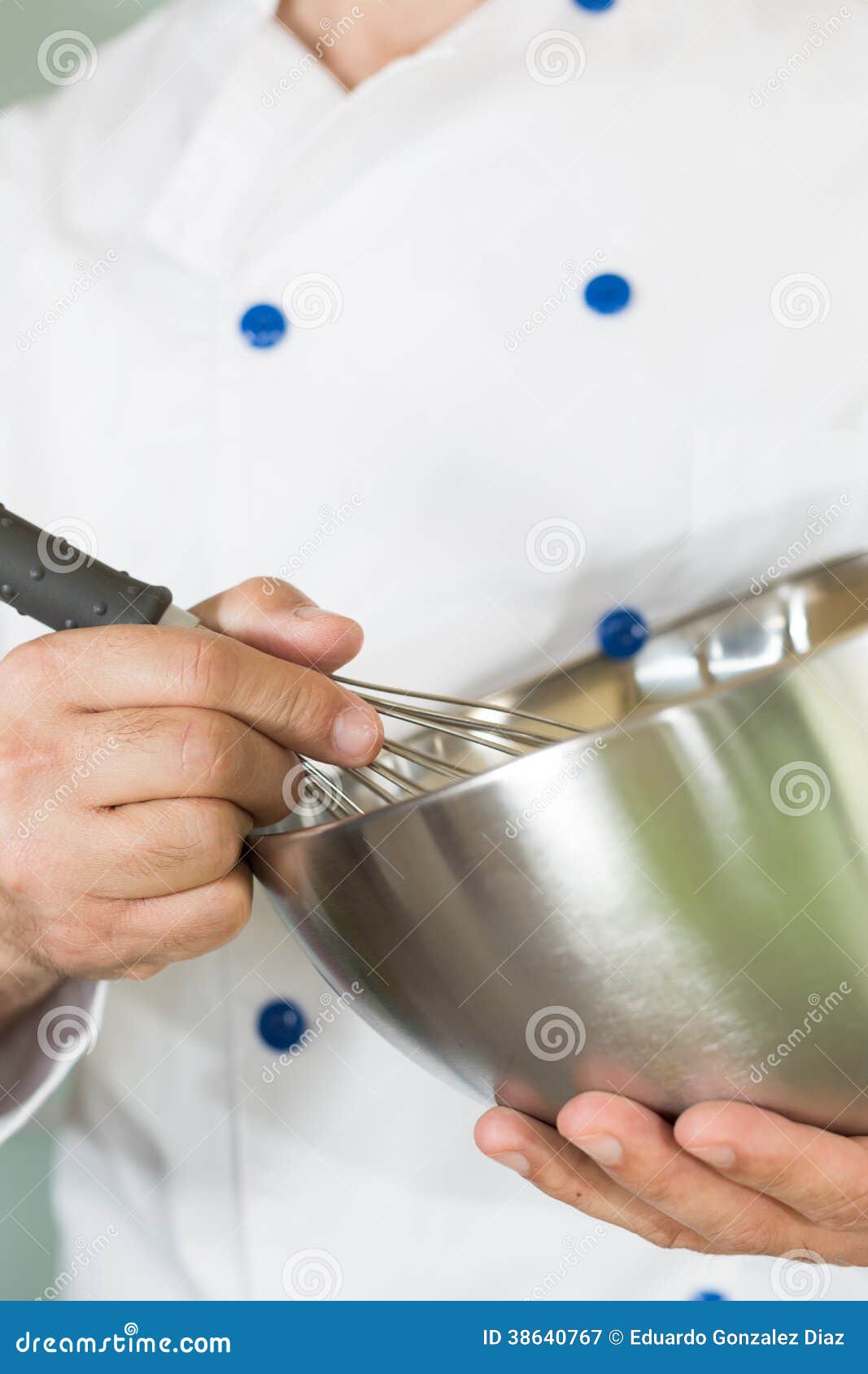 Cook whisking cream in the kitchen to make a cake