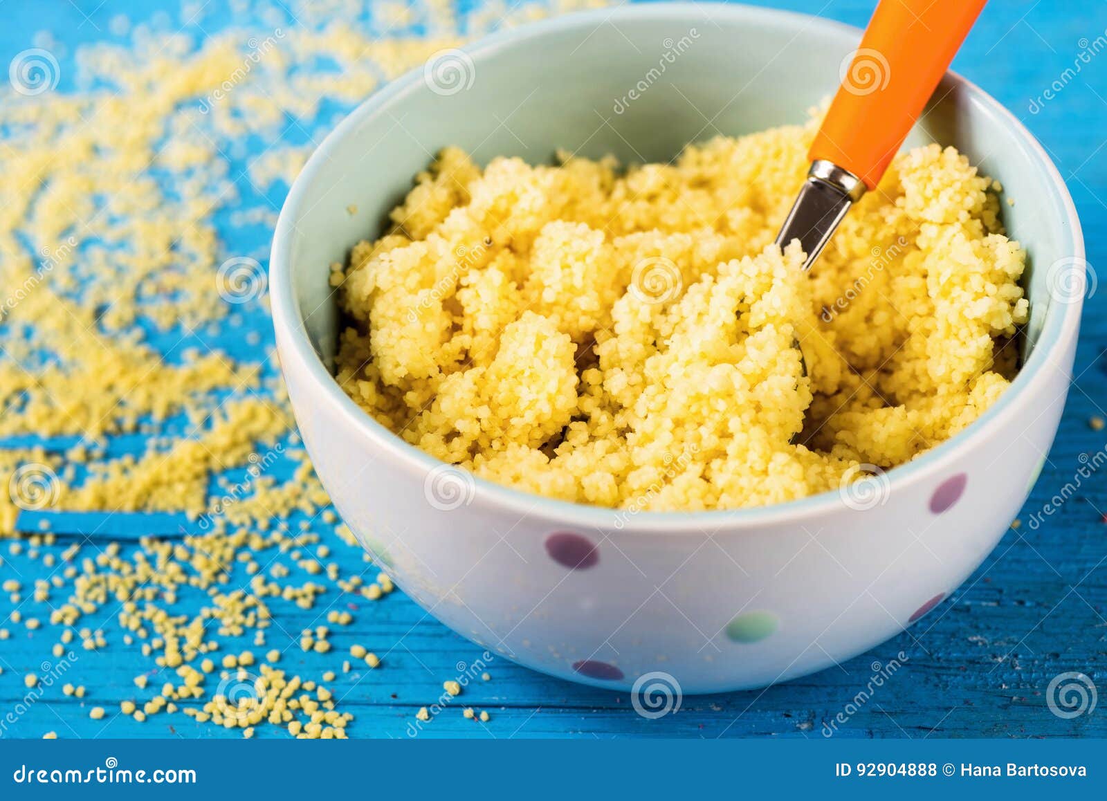 Cooked Couscous in Bowl on Blue Background, Closeup. Stock Photo