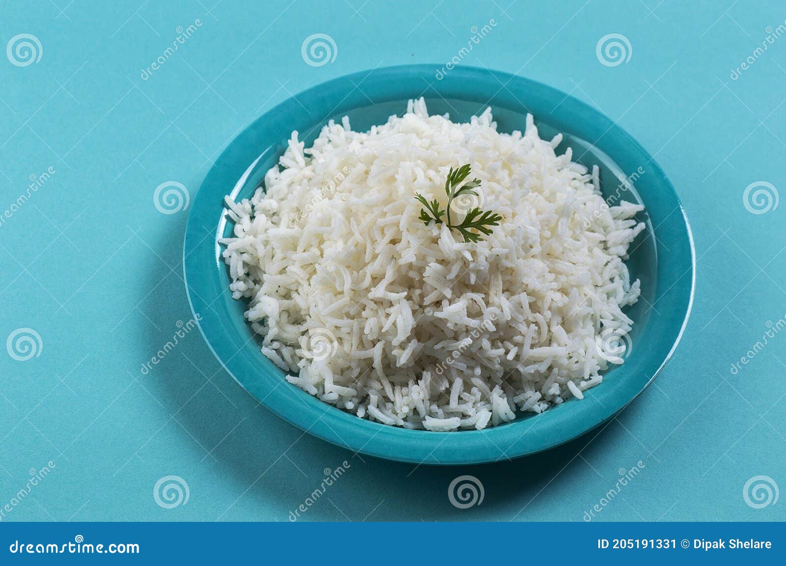 Cooked Plain White Basmati Rice with Corriander in a Blue Plate on Blue