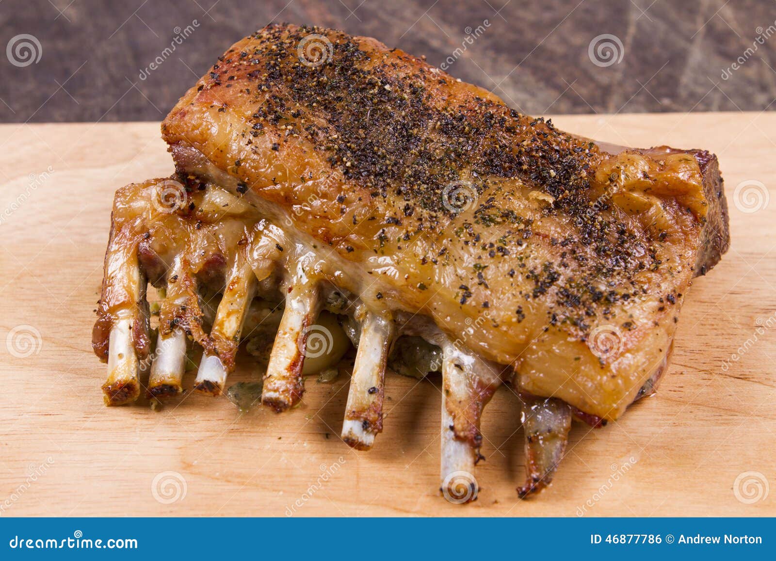 A cooked rack of lamb on a board