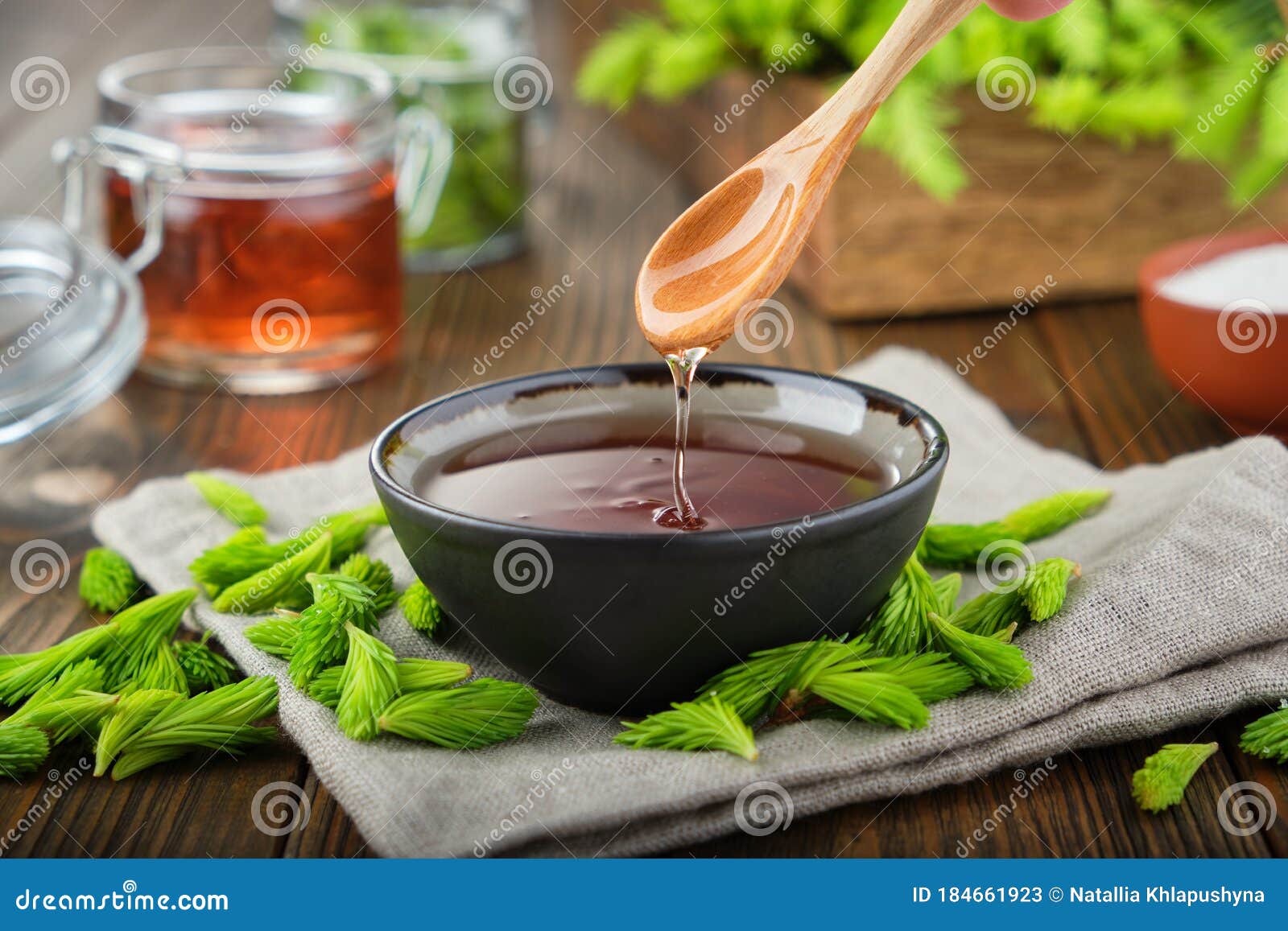 cooked syrup or honey from spruce tips in a black bowl, jar of jam or honey from fir buds and needles.