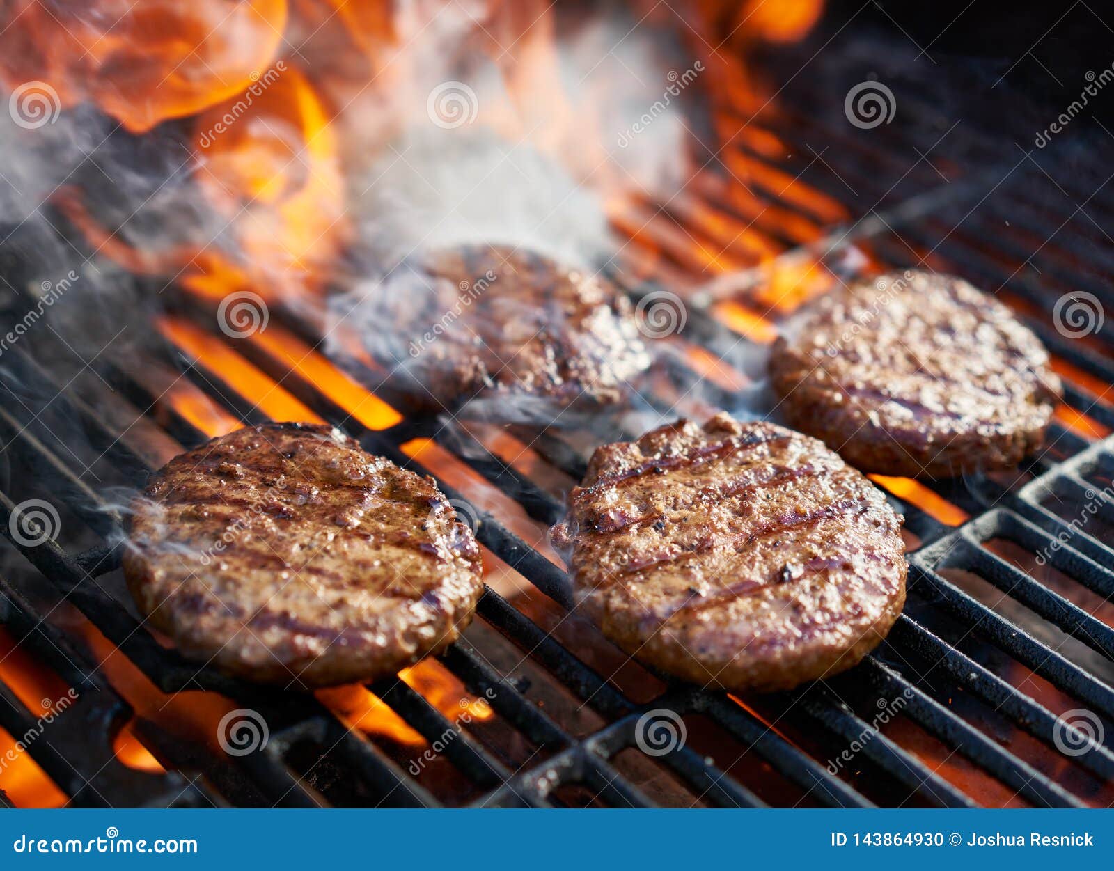 cooking burgers on hot grill with flames