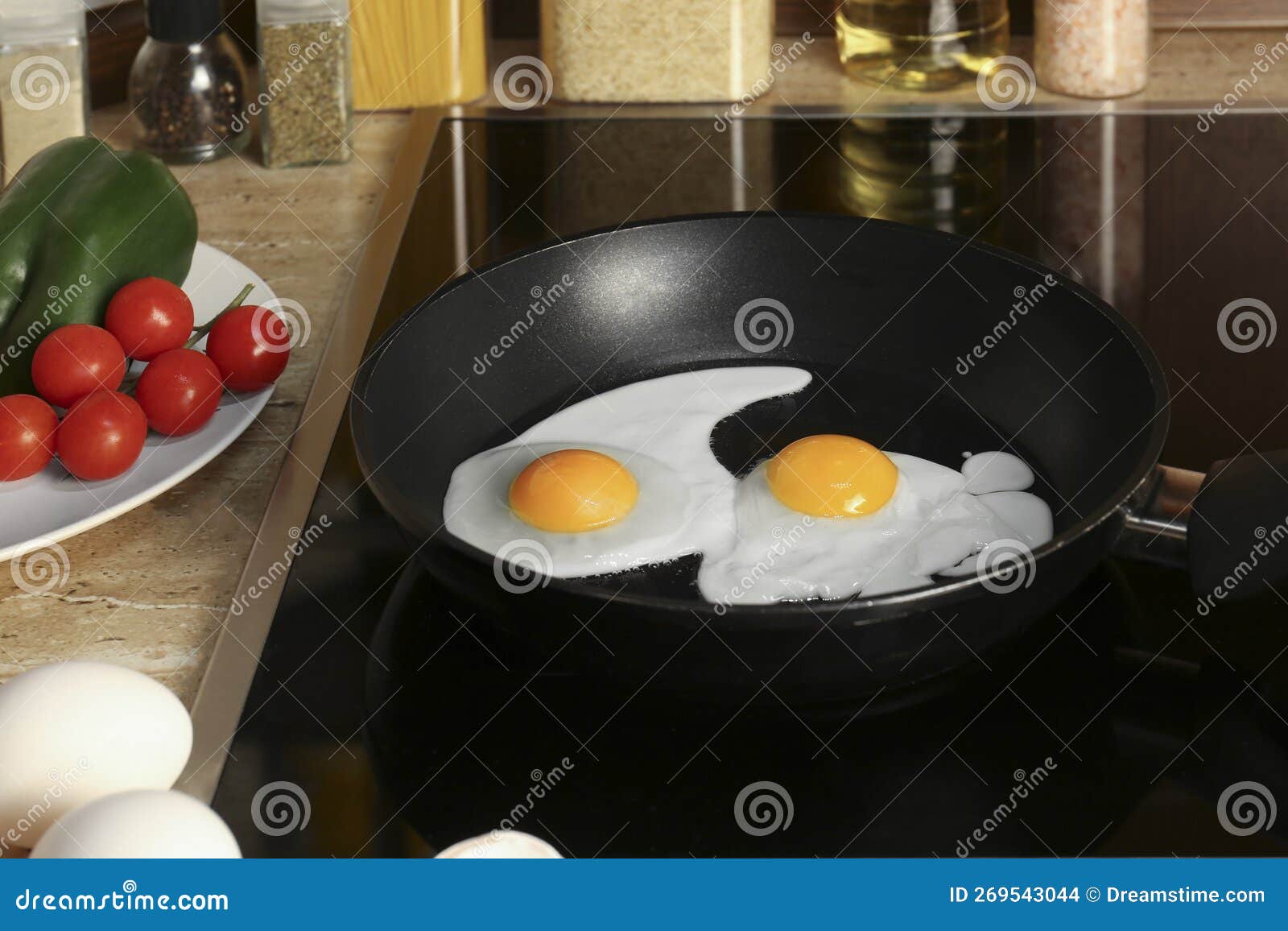 Cooking Eggs for Breakfast in Frying Pan on Cooktop Stock Photo Image