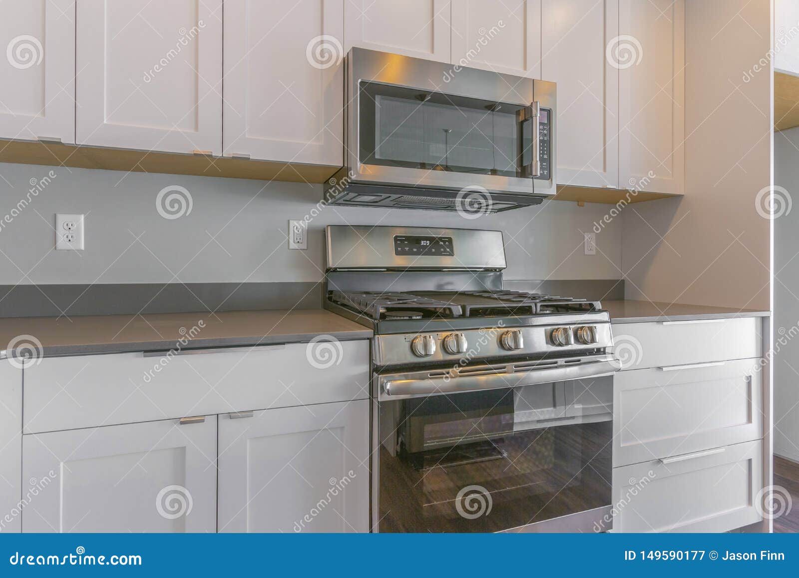 Cooking Range And Wall Mounted Microwave Inside A Modern Kitchen