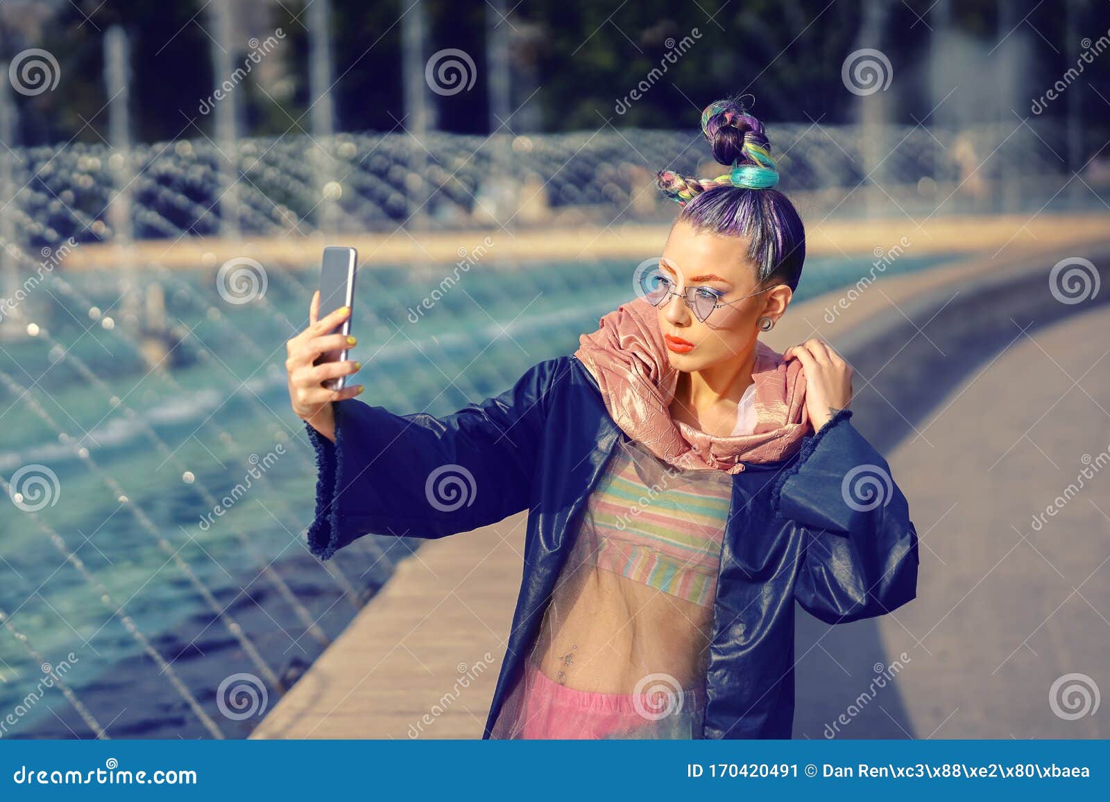 cool funky hipster young fashion influencer girl with crazy hair and avant garde style taking selfie on street