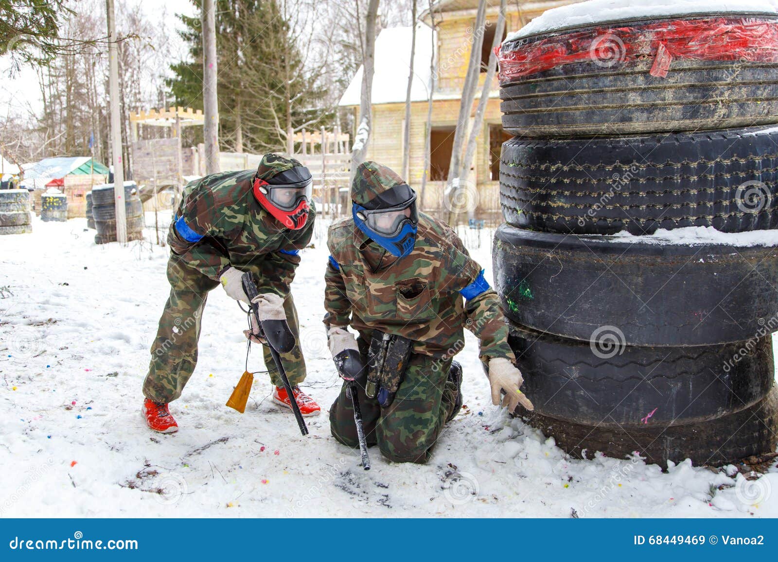 Cool Paintball in Winter. Two Shooters Behind Fortifications. Stock