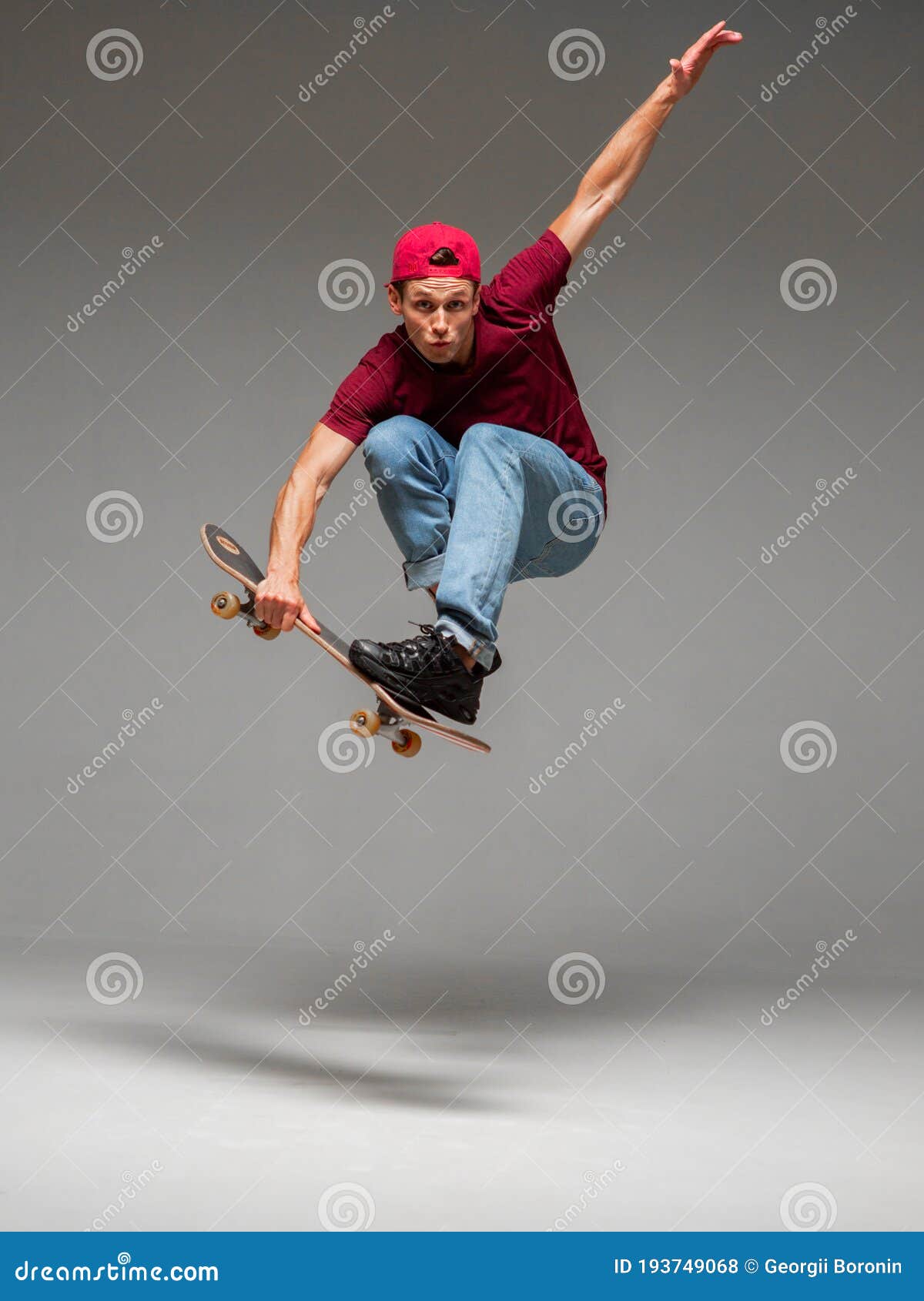 Cool Young Guy Skateboarder Jumps on Skateboard in Studio on Gray ...