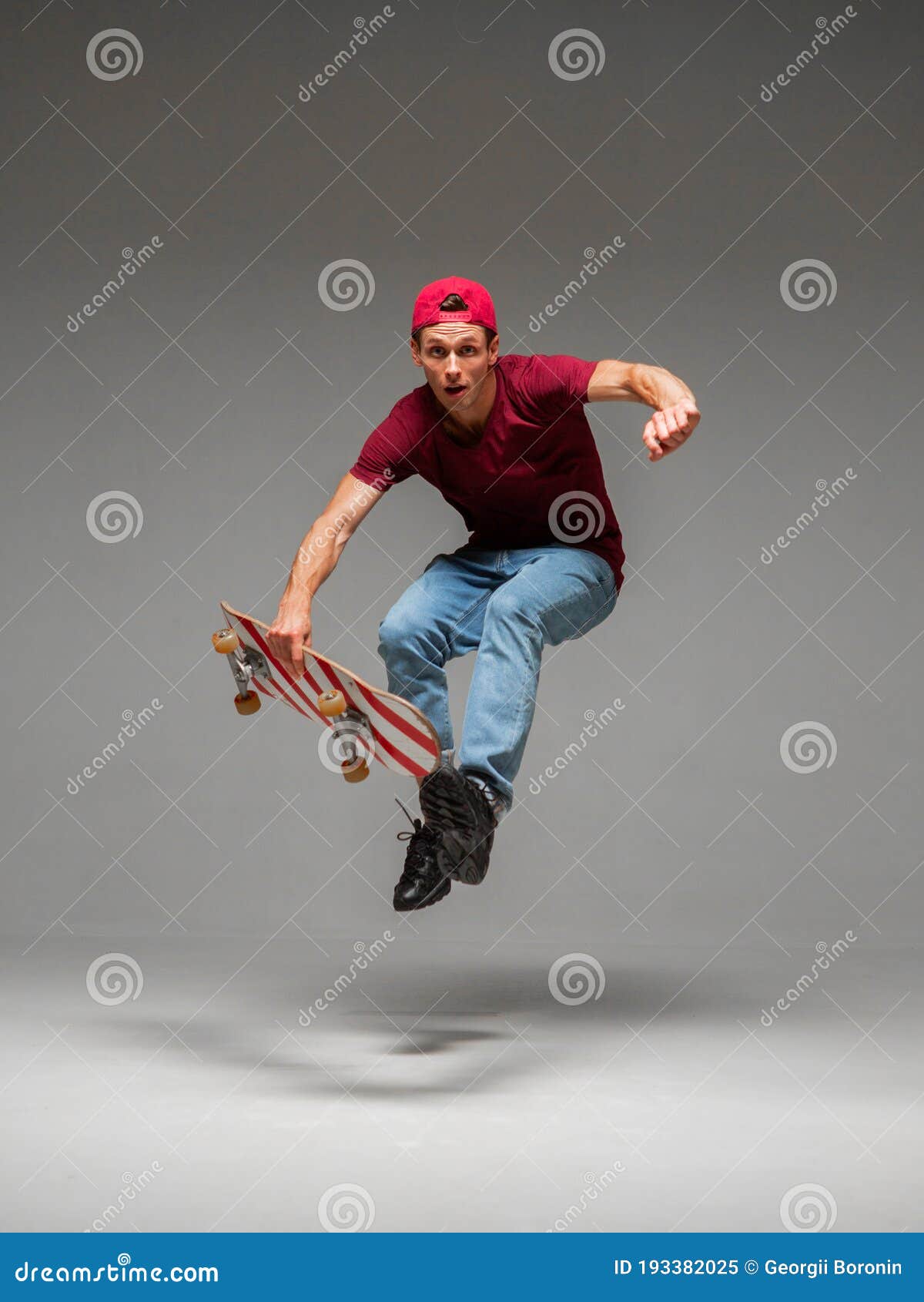 Cool Young Guy Skateboarder Jumps on Skateboard in Studio on Grey ...