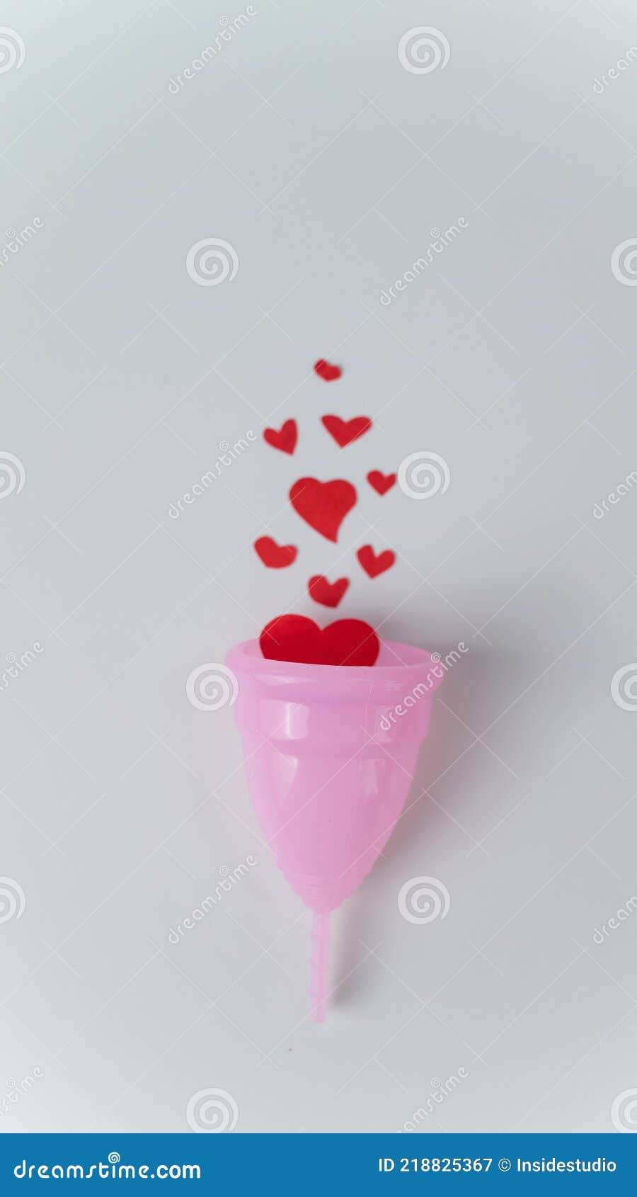 Copo menstrual branco com corações vermelhos simbolizando a menstruação em  rosa
