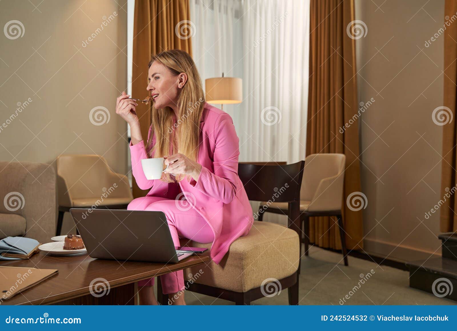 joyous lady in fancy pink outfit eating dessert at hotel