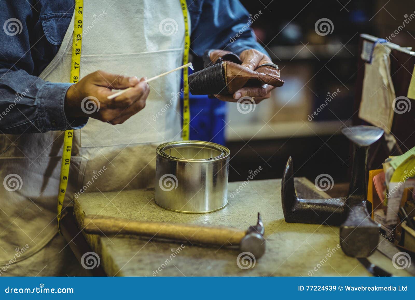 Cordonnier Appliquant La Colle Sur La Chaussure Image stock