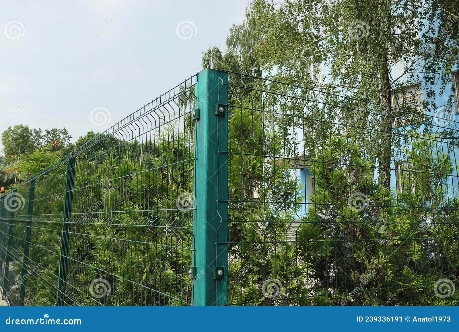 Corner of a Green Wall of a Fence Made of an Iron Post and a Metal Mesh