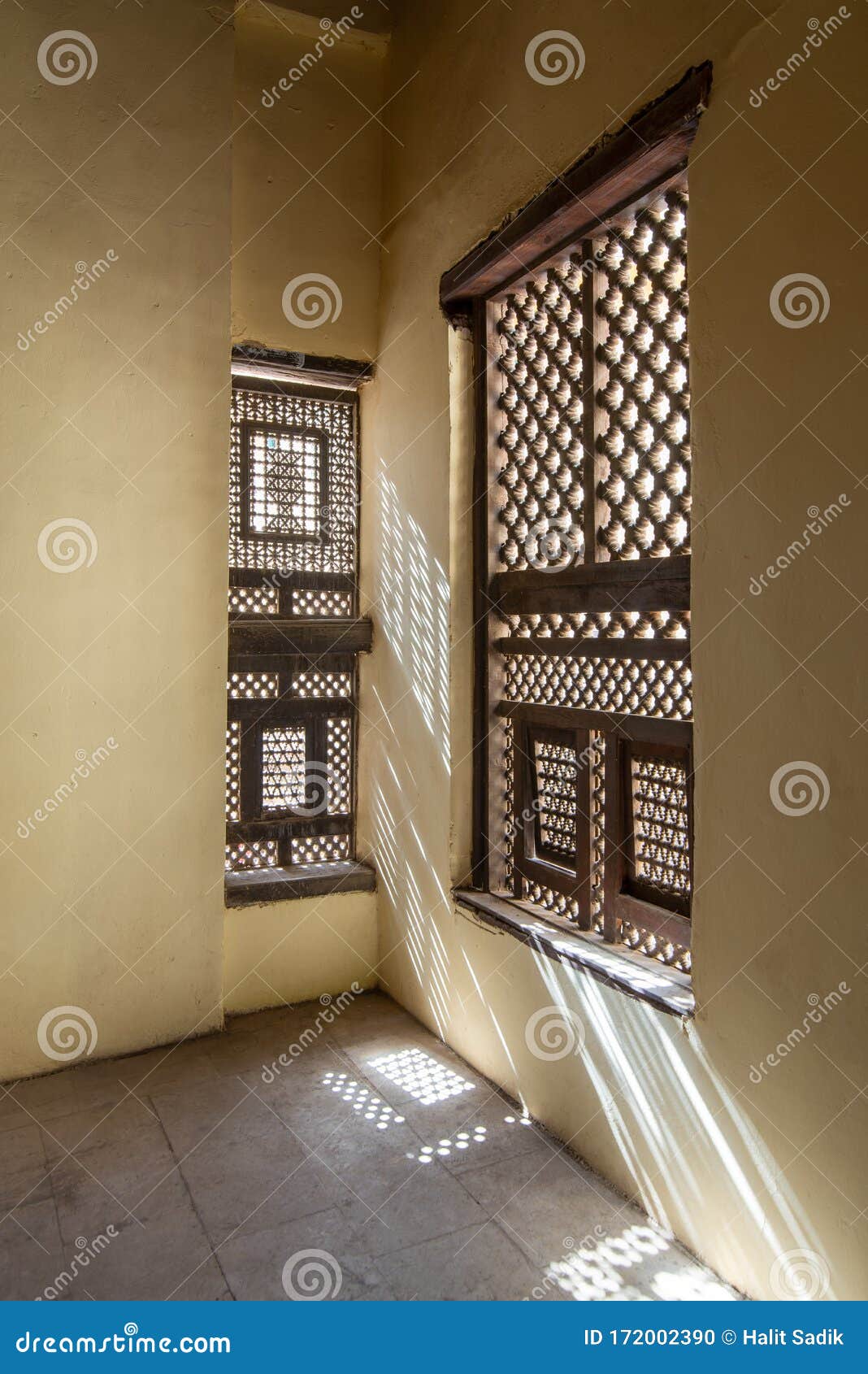 corner of two interleaved wooden ornate windows - mashrabiya - in stone wall