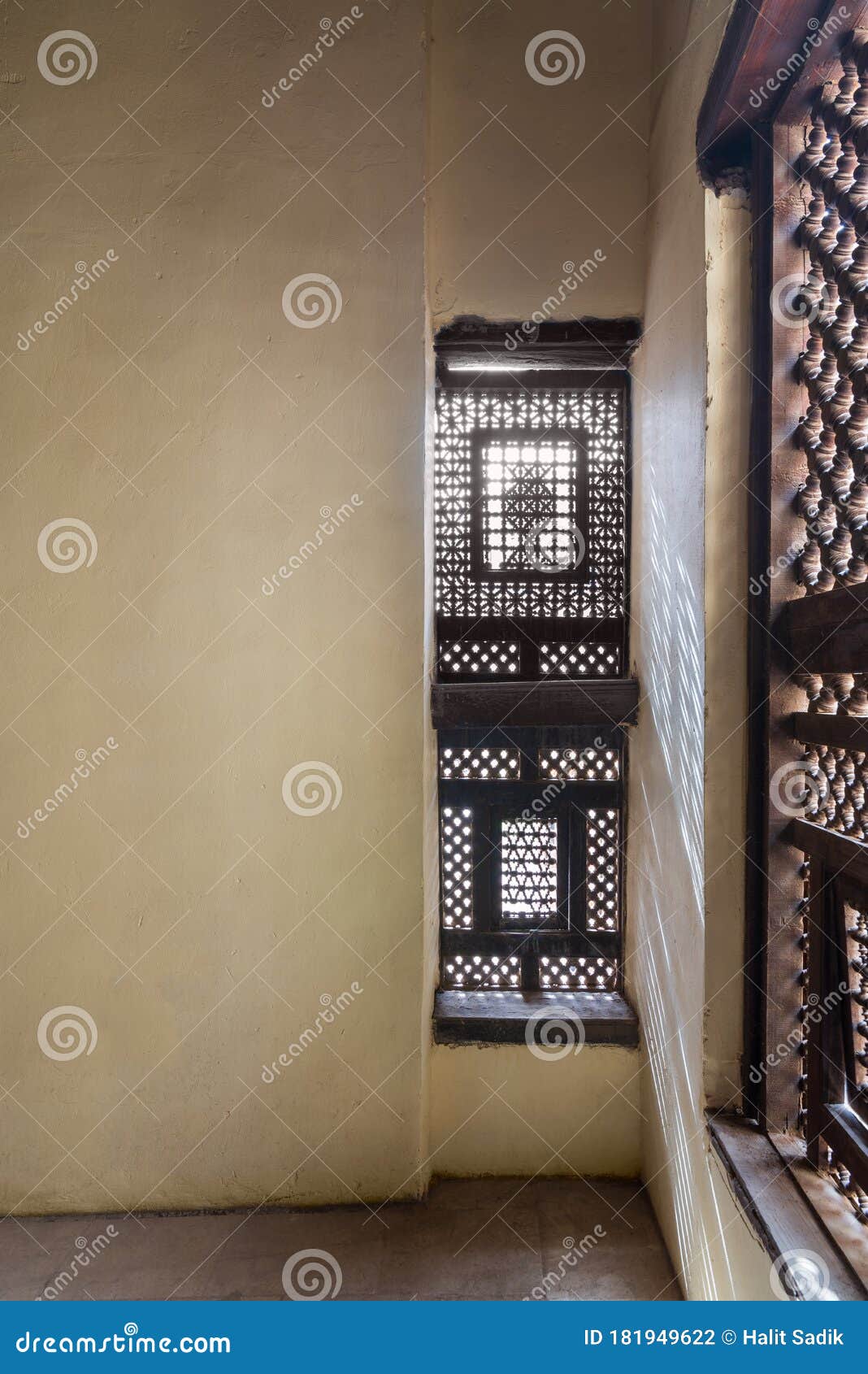 corner of two interleaved wooden ornate windows - mashrabiya - in stone wall