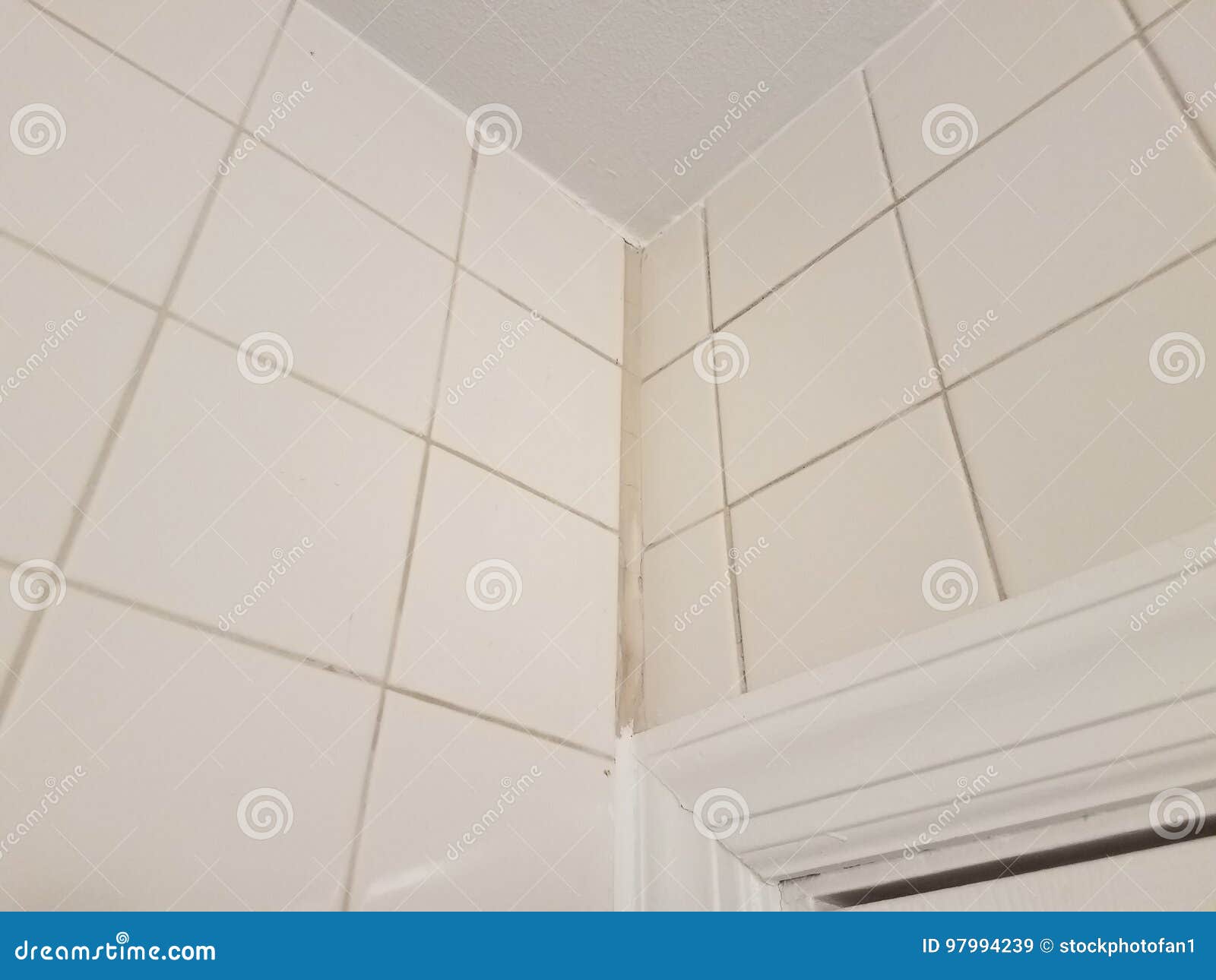 corner in white tile bathroom with white calk