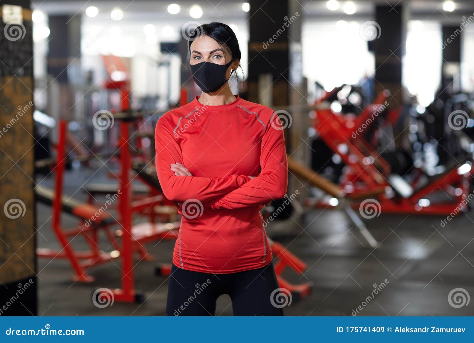 coronavirus covid-19 prevention, fitness girl with a medical mask posing in gym. fighting viruses
