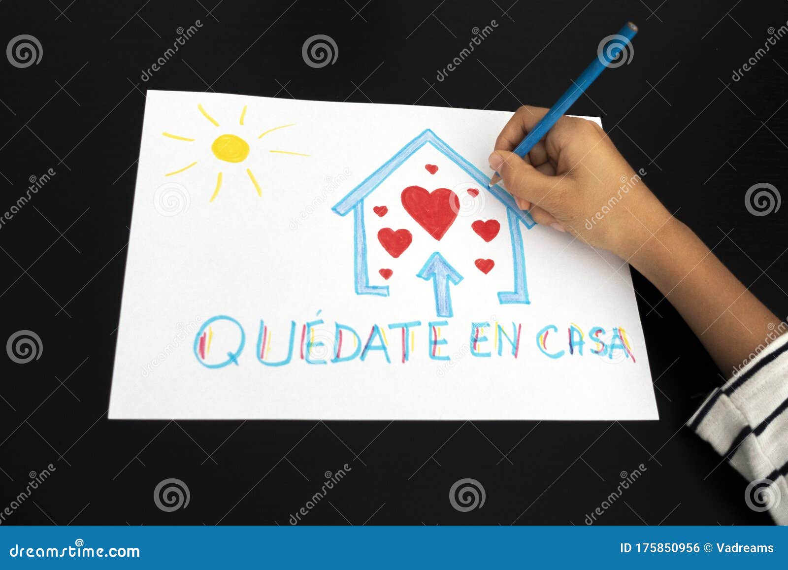 coronavirus quarantine in spain. kid hand draw picture with spanish words quedate en casa - stay at home