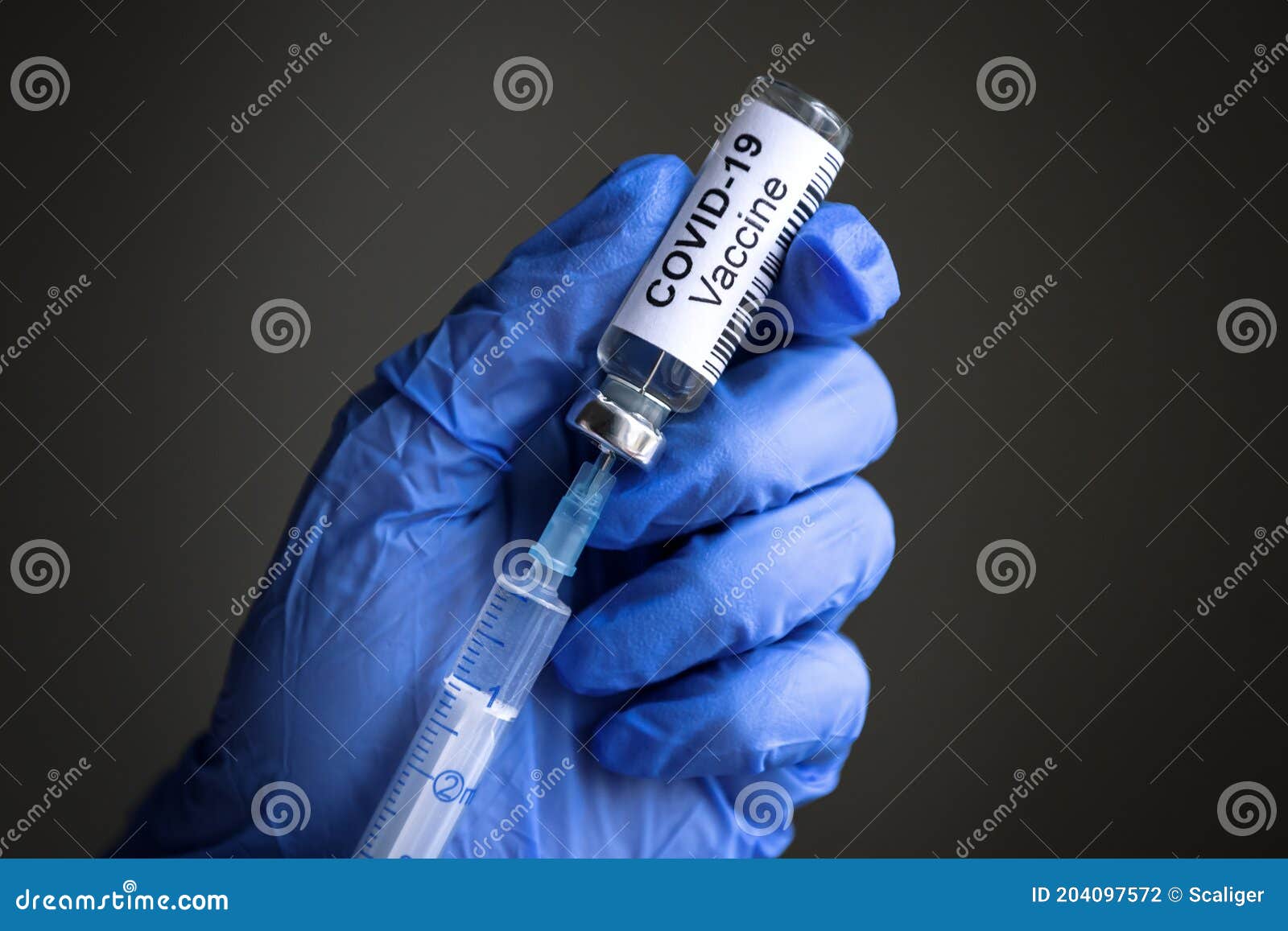 coronavirus vaccine bottle and syringe for covid-19 cure in doctorÃ¢â¬â¢s gloved hands