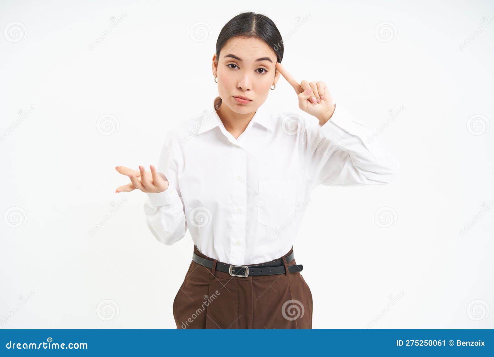 corporate woman looks annoyed, points finger at head, mocks someone, scolding person, white background