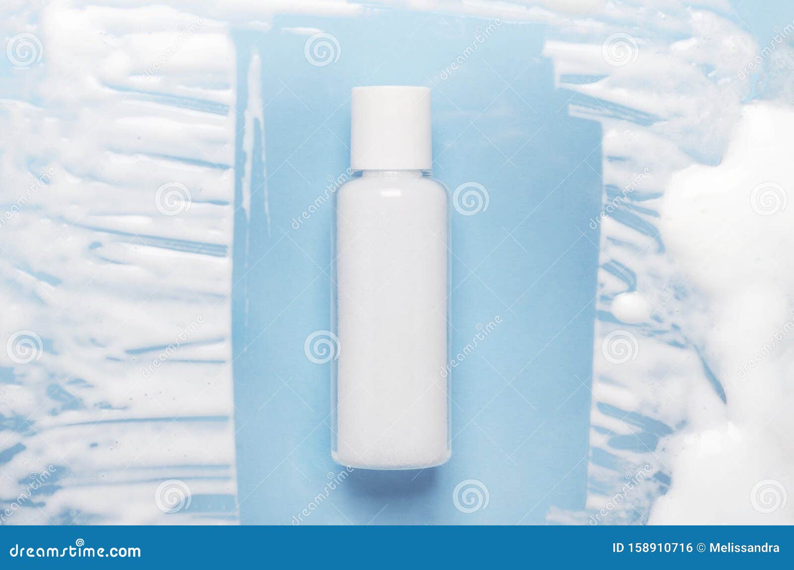 Download Cosmetic Lotion Bottle Mockup On Blue Background With Foamy Smears Face Washing Mousse Top View Moisturizing Body Stock Photo Image Of Hair Blue 158910716
