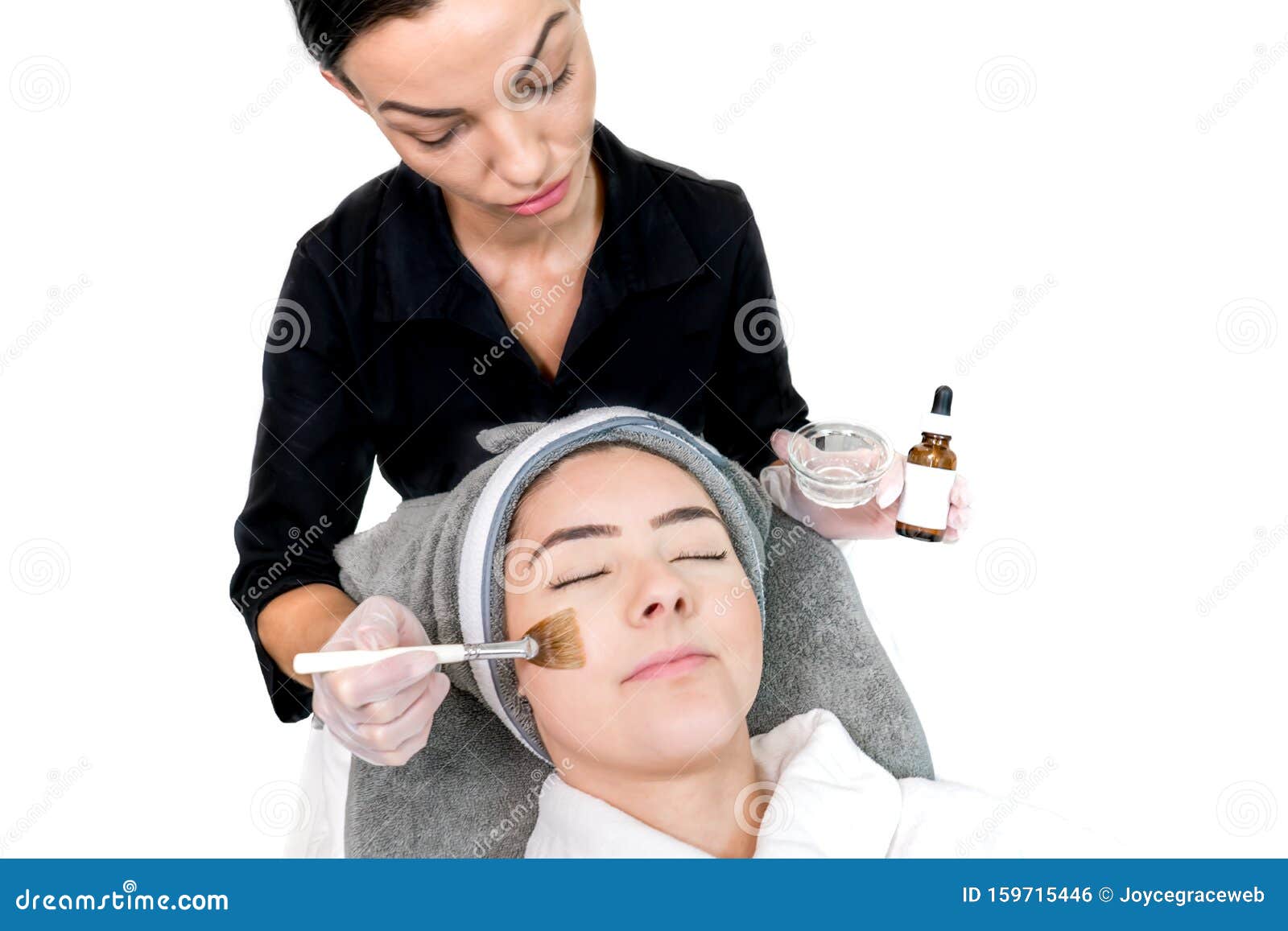 Cosmetologist Administering Chemical Peel Treatment On Patient In A