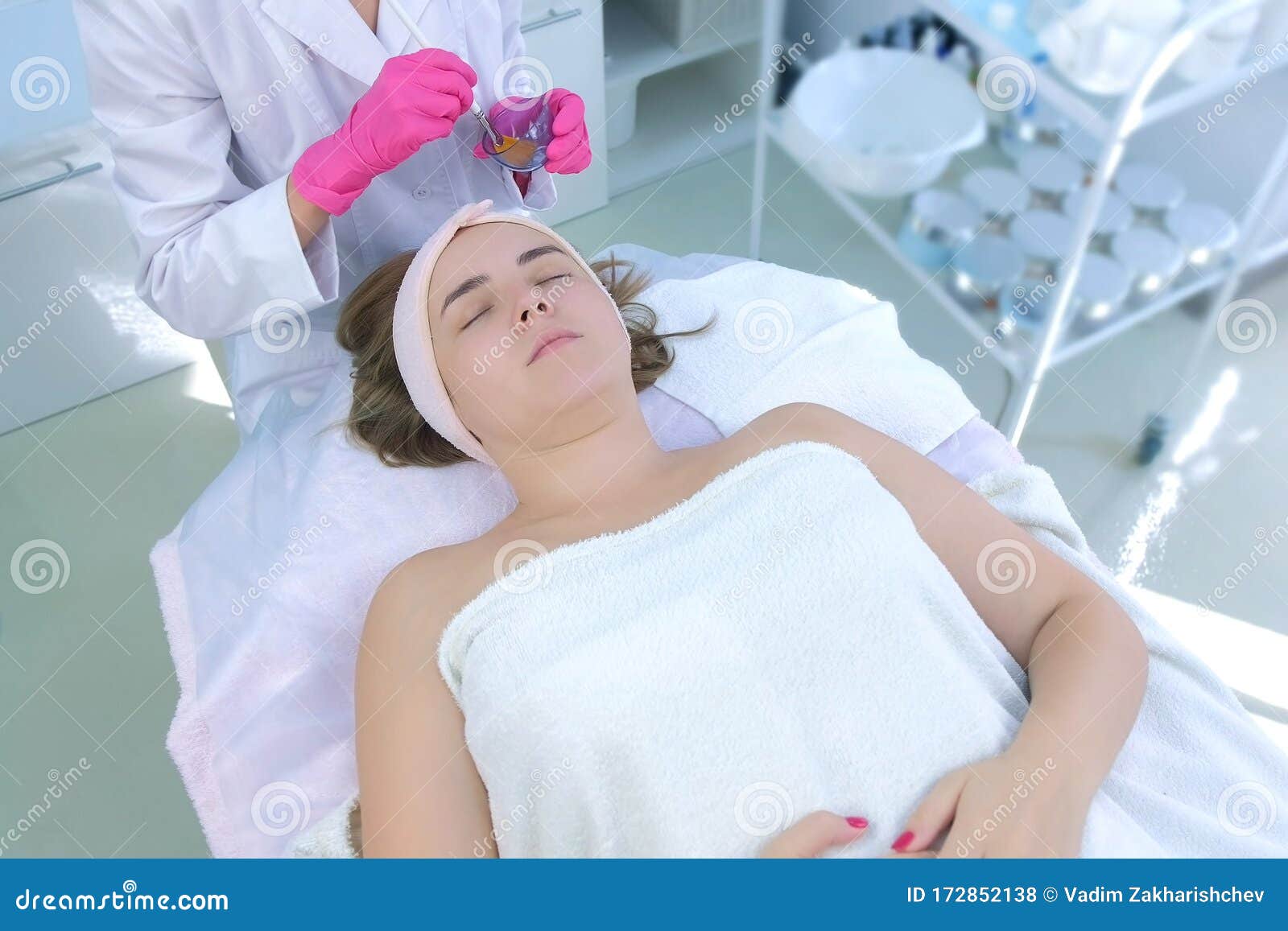Cosmetologist Applying Peeling Lotion On Woman`s Face Using Brush In