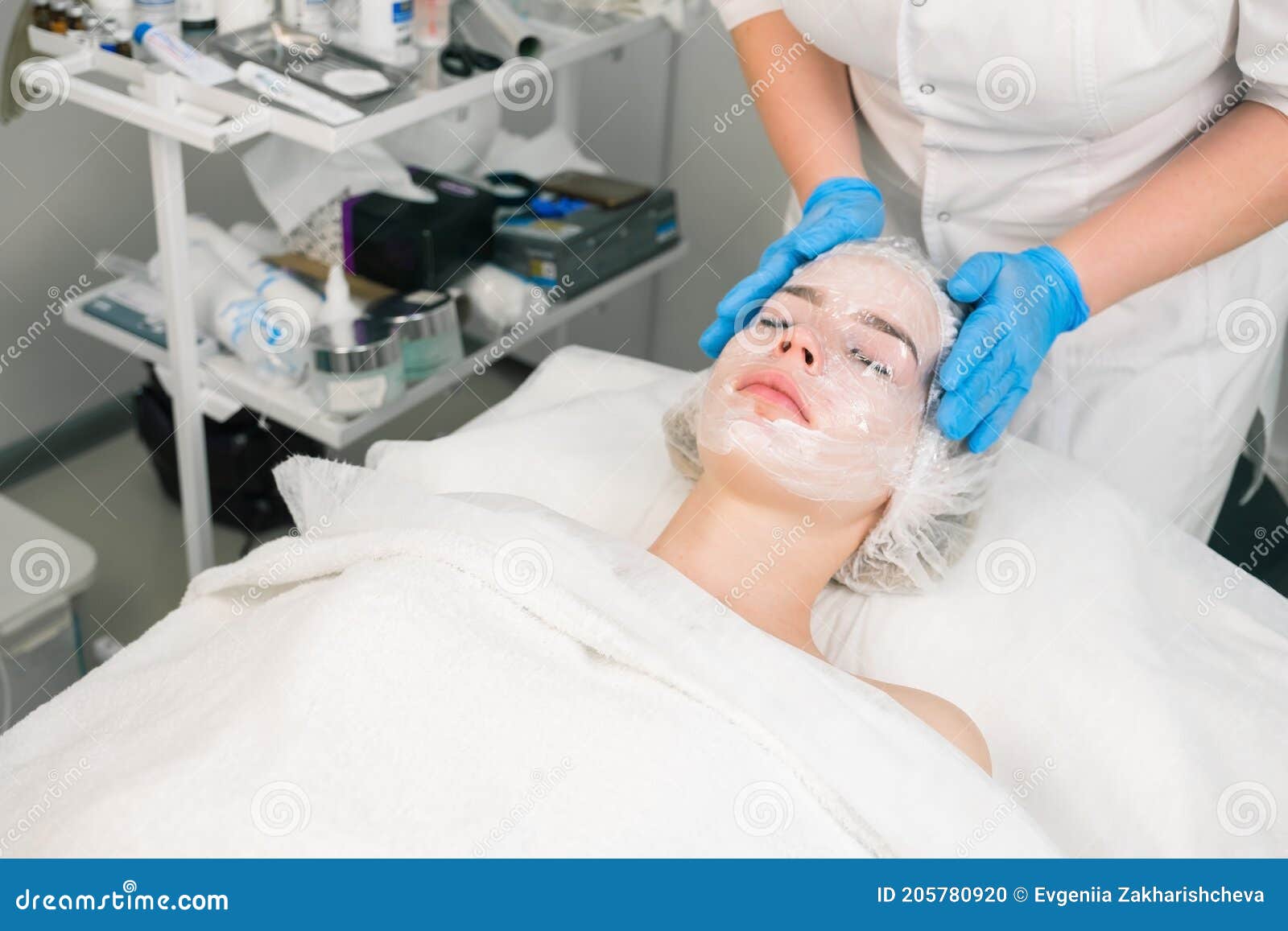 Cosmetologist Doctor Applies Film on Cream with Anesthesia on Woman`s Face. - of patient, beautician: 205780920