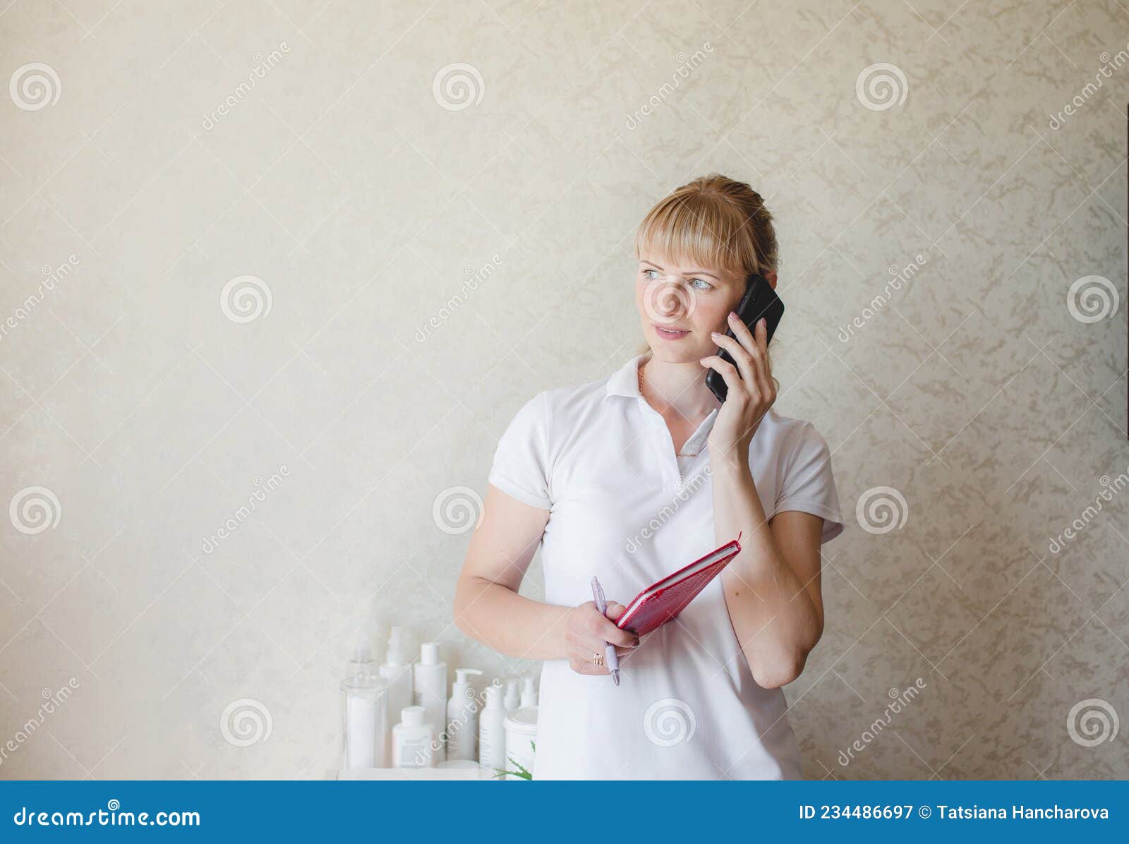 a cosmetologist girl consults a client by phone. pre-registration