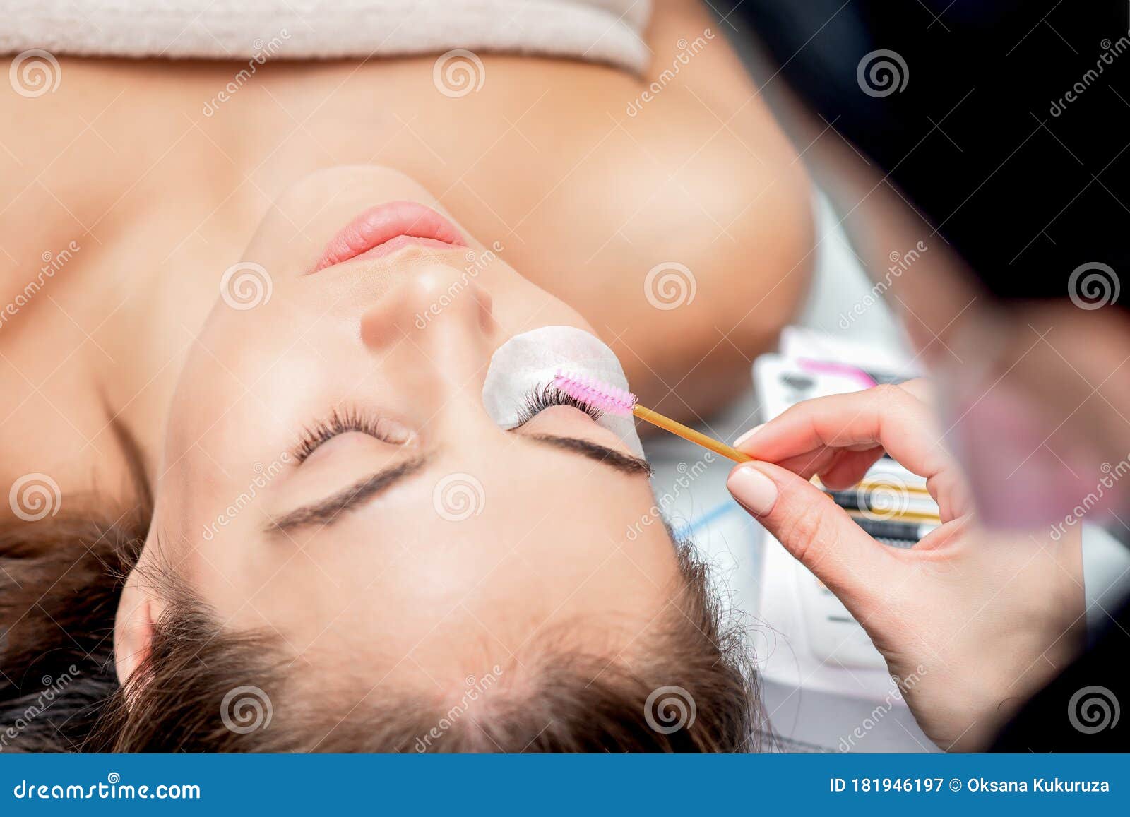 cosmetologist hand making lengthening lashes