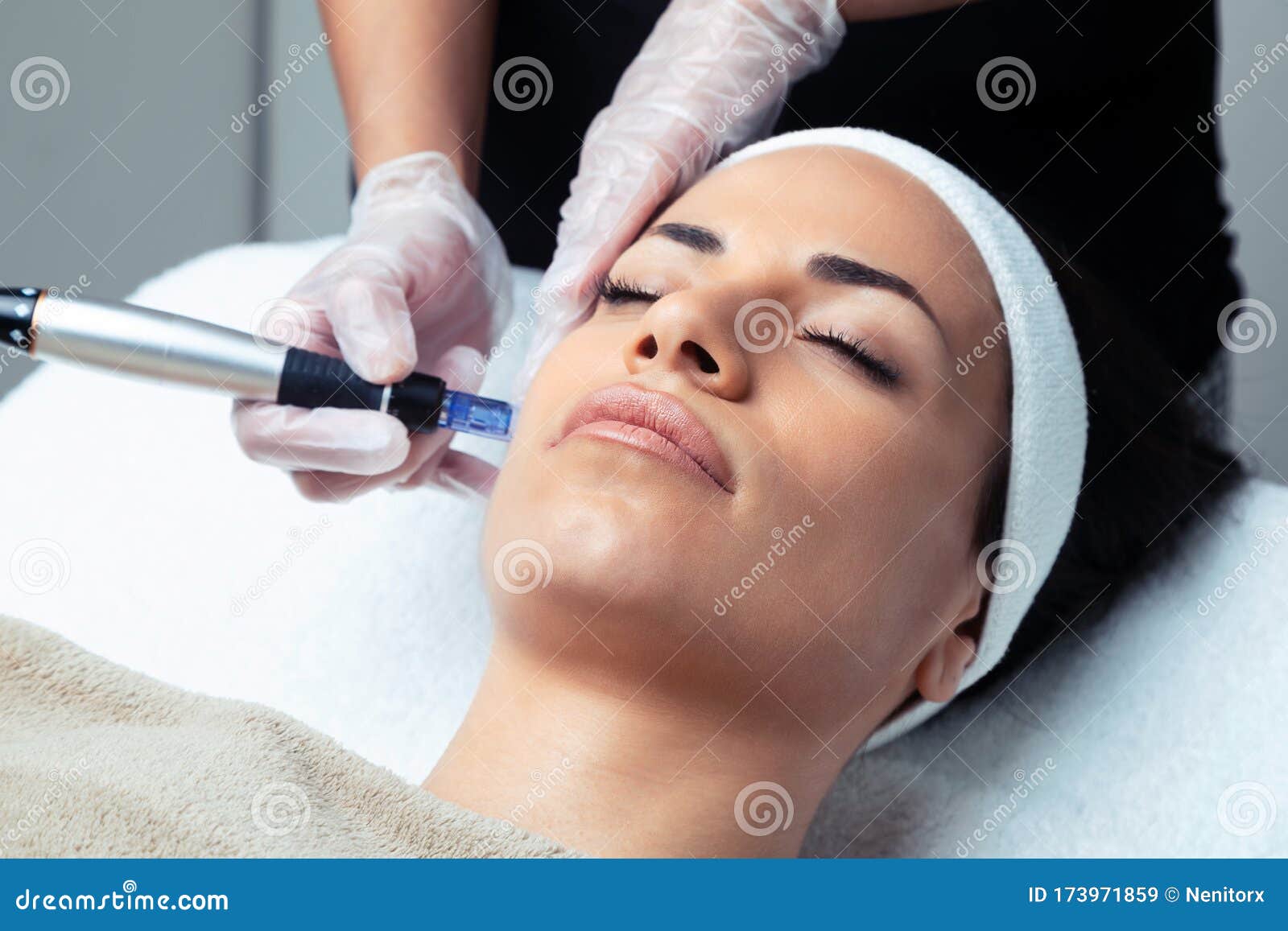 cosmetologist making mesotherapy injection with dermapen on face for rejuvenation on the spa center