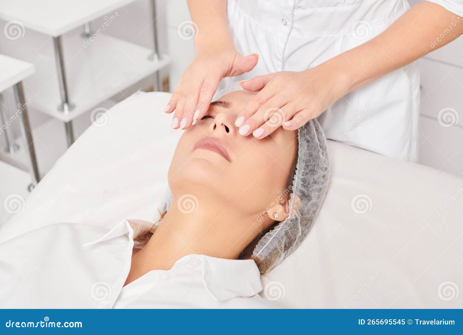 Cosmetologist Massages Woman Face Skin After Rubbing Moisturizing Cream For Rejuvenation In