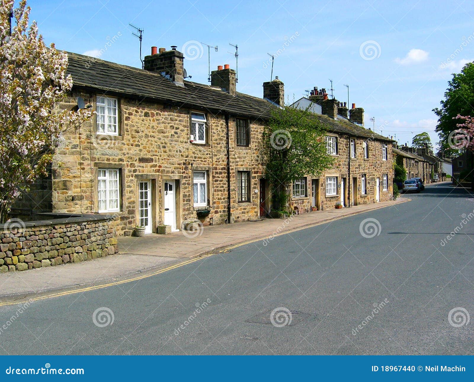 Cottage in Embsay, Yorkshire del nord. Una riga tipica della pietra ha costruito i cottage terracced sul main streen in Embsay Yorkhire del nord, sul bordo della sosta nazionale delle vallate del Yorkshire