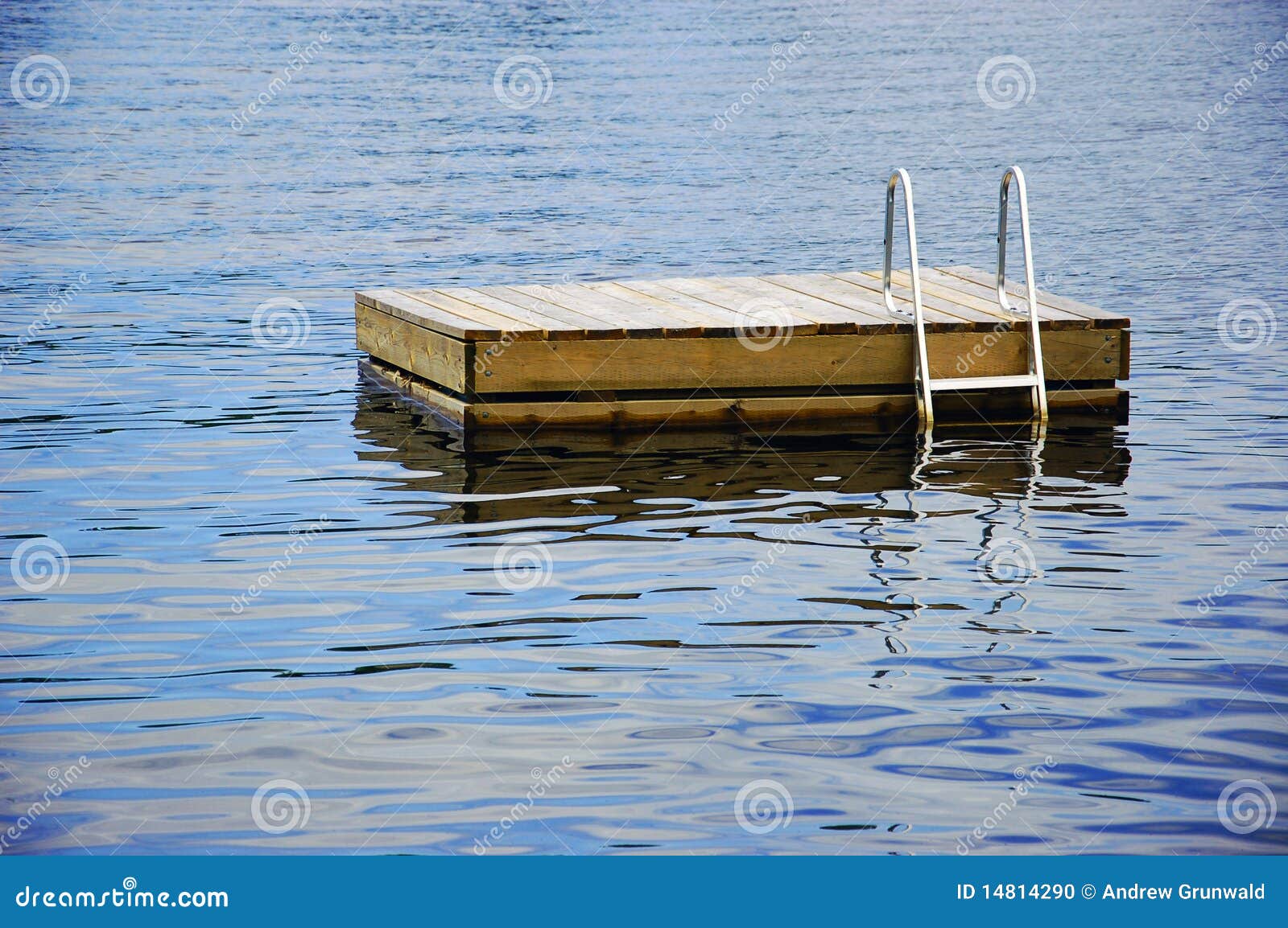 wood swimming raft with a metal ladder floating in a lake.