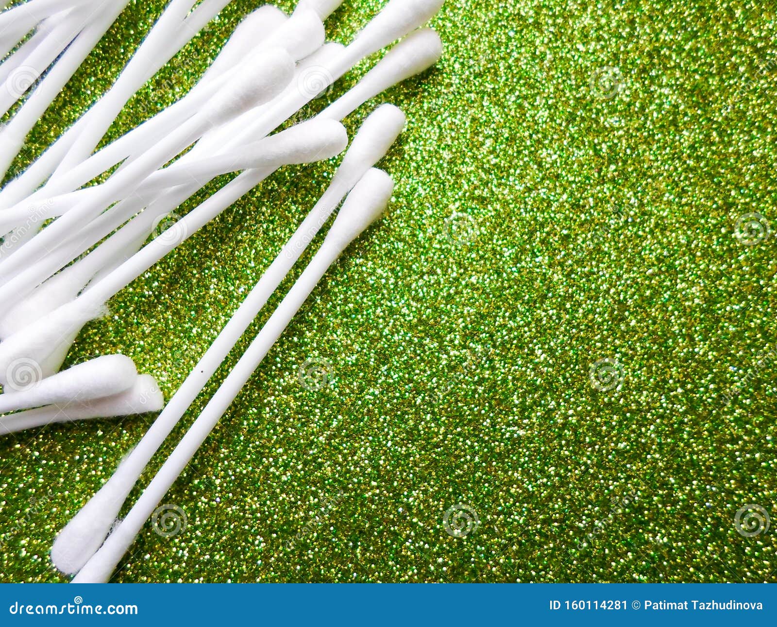 cotton buds on a green background. sanitary accessory. cotton buds for cleaning ears