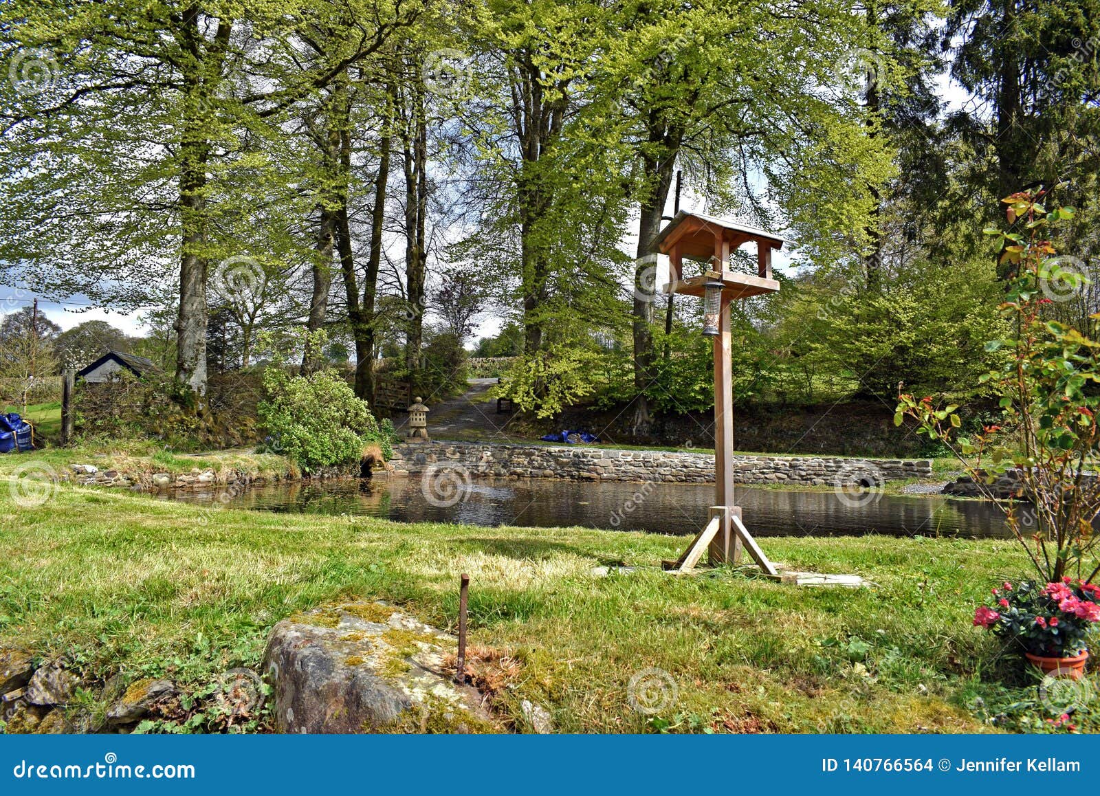 A Large Garden Pond Surrounded By Trees Shrubs Grass And Farm