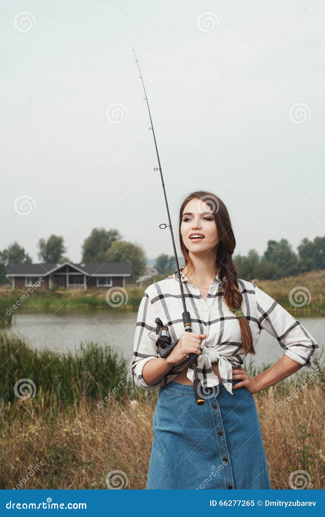 Country Lady Standing Against Pond on Ranch with Fish-rod Stock