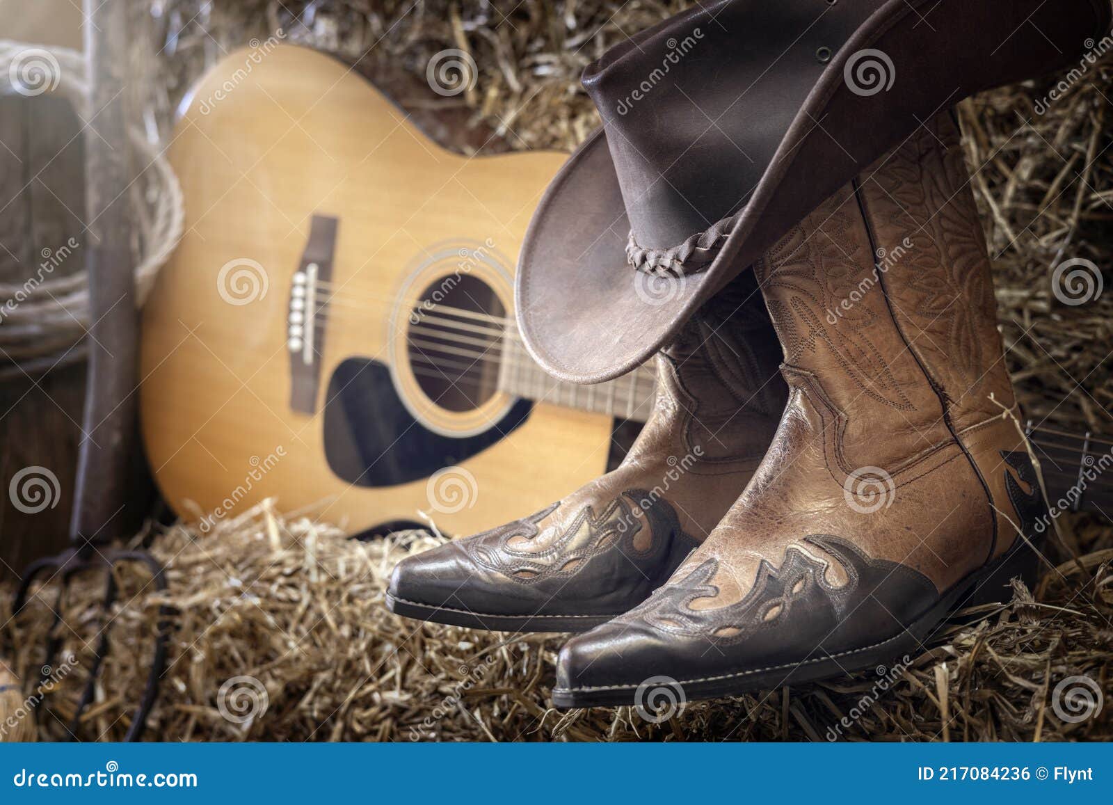 country music festival live concert or rodeo with cowboy hat guitar and boots in barn