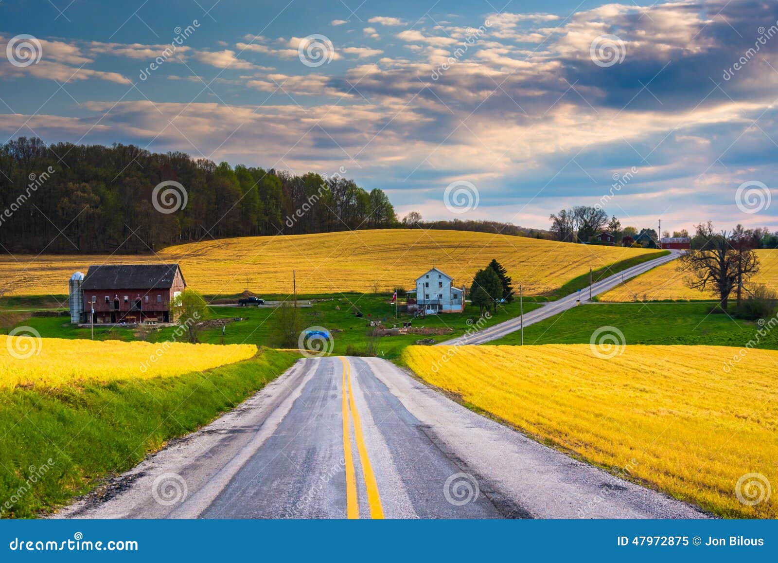 country road and view of farm fields and hills in rural york county, pennsylvania.