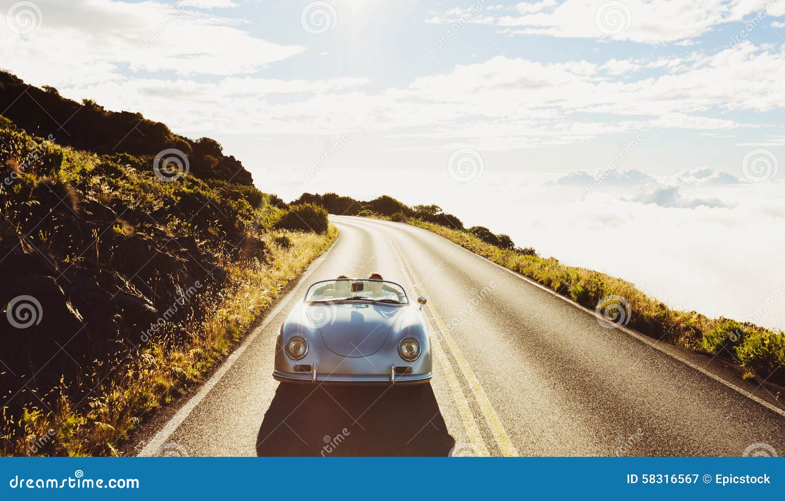 coupe driving on country road in vintage sports car