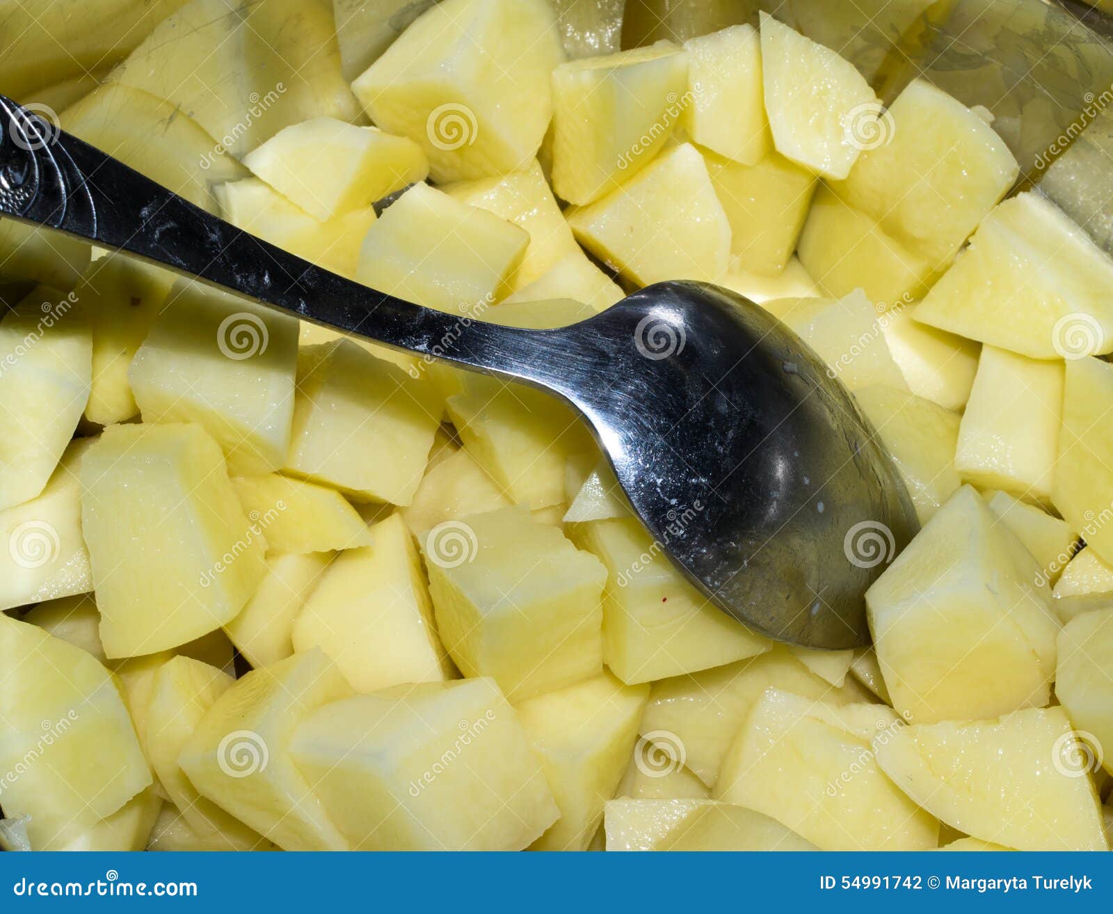 Coupez les pommes de terre crues et la cuillère dans une casserole. Coupez les pommes de terre et la cuillère fraîches crues dans une casserole en métal