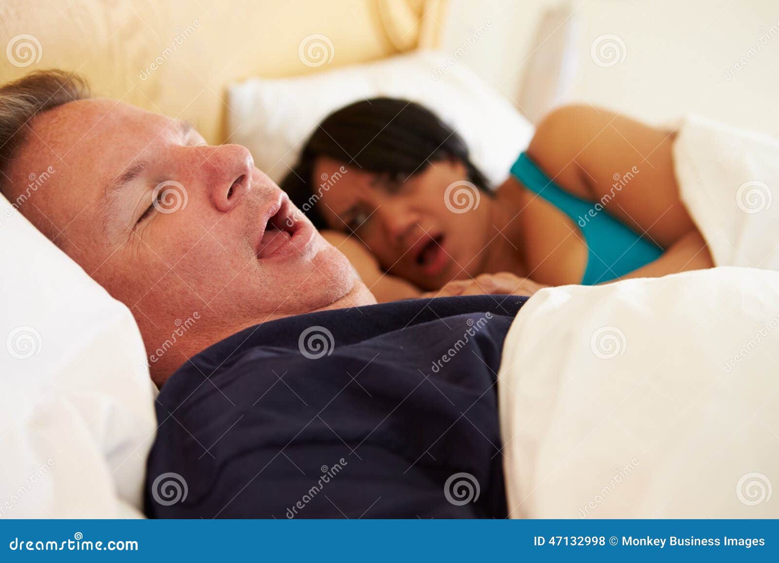 couple asleep in bed with man snoring