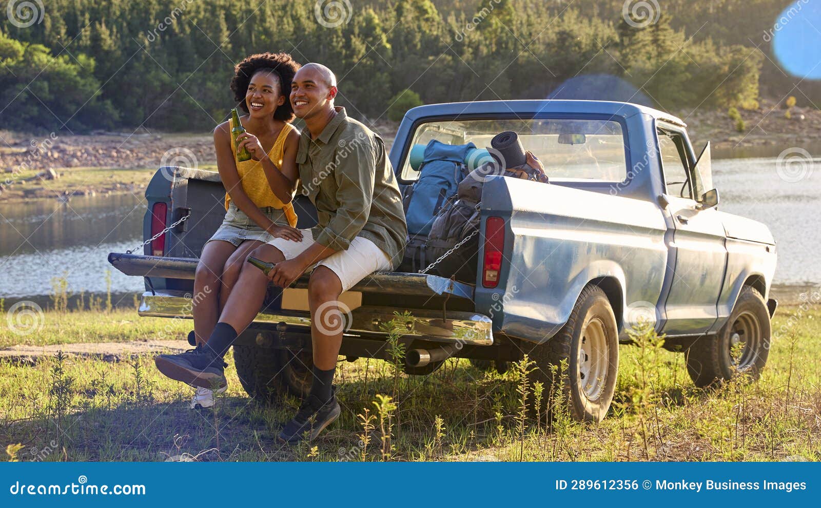 Couple having beer on a pickup truck bonnet Stock Photo - Alamy