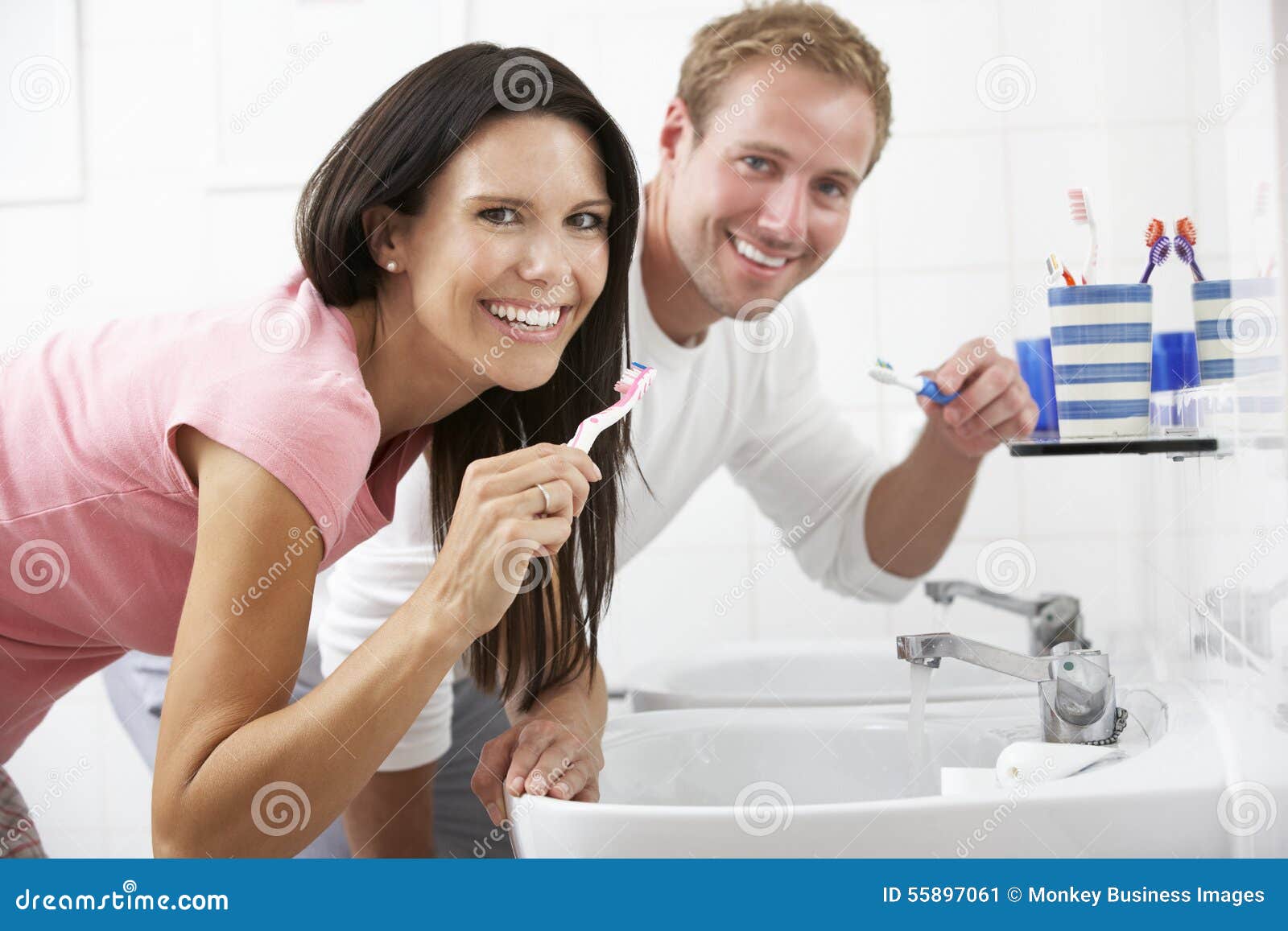couple in bathroom brushing teeth