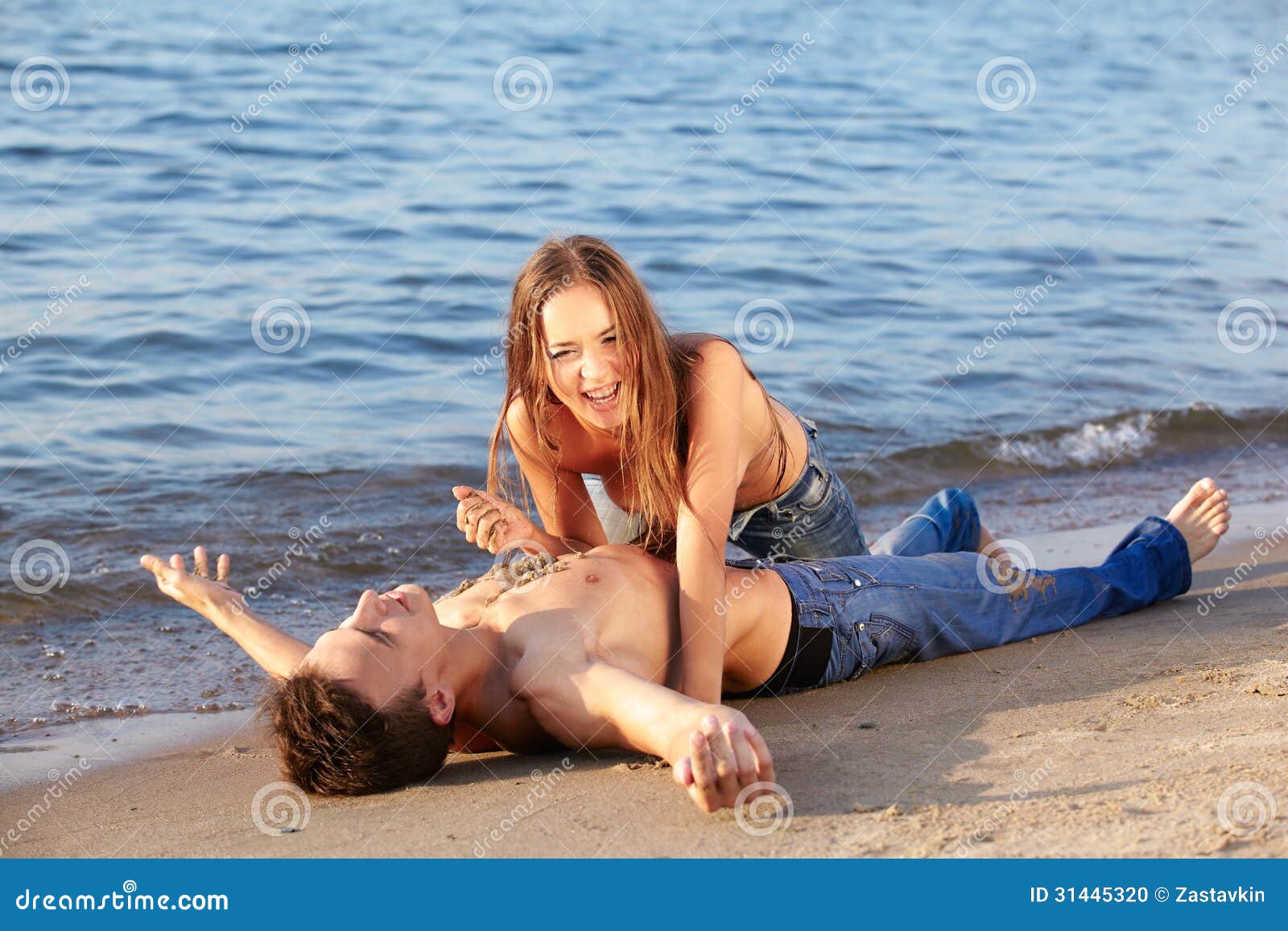 Topless ladies surrounded by dressed men at the beach