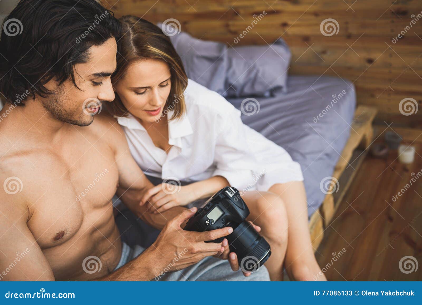Couple on a Bed Watching Pictures Stock Image photo