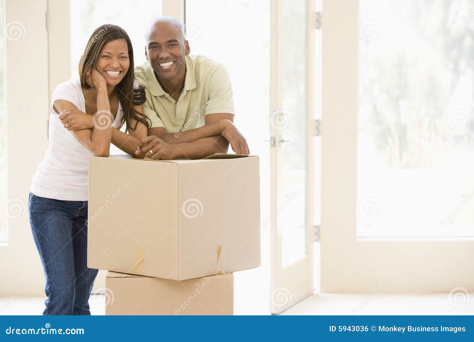 couple with boxes in new home smiling
