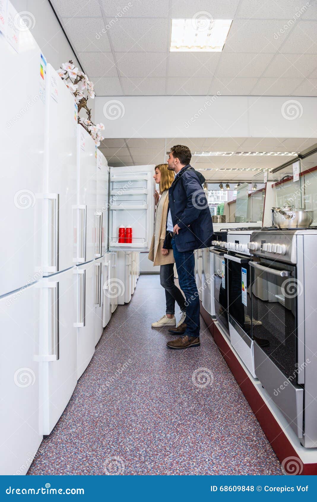 couple buying refrigerator in hypermarket