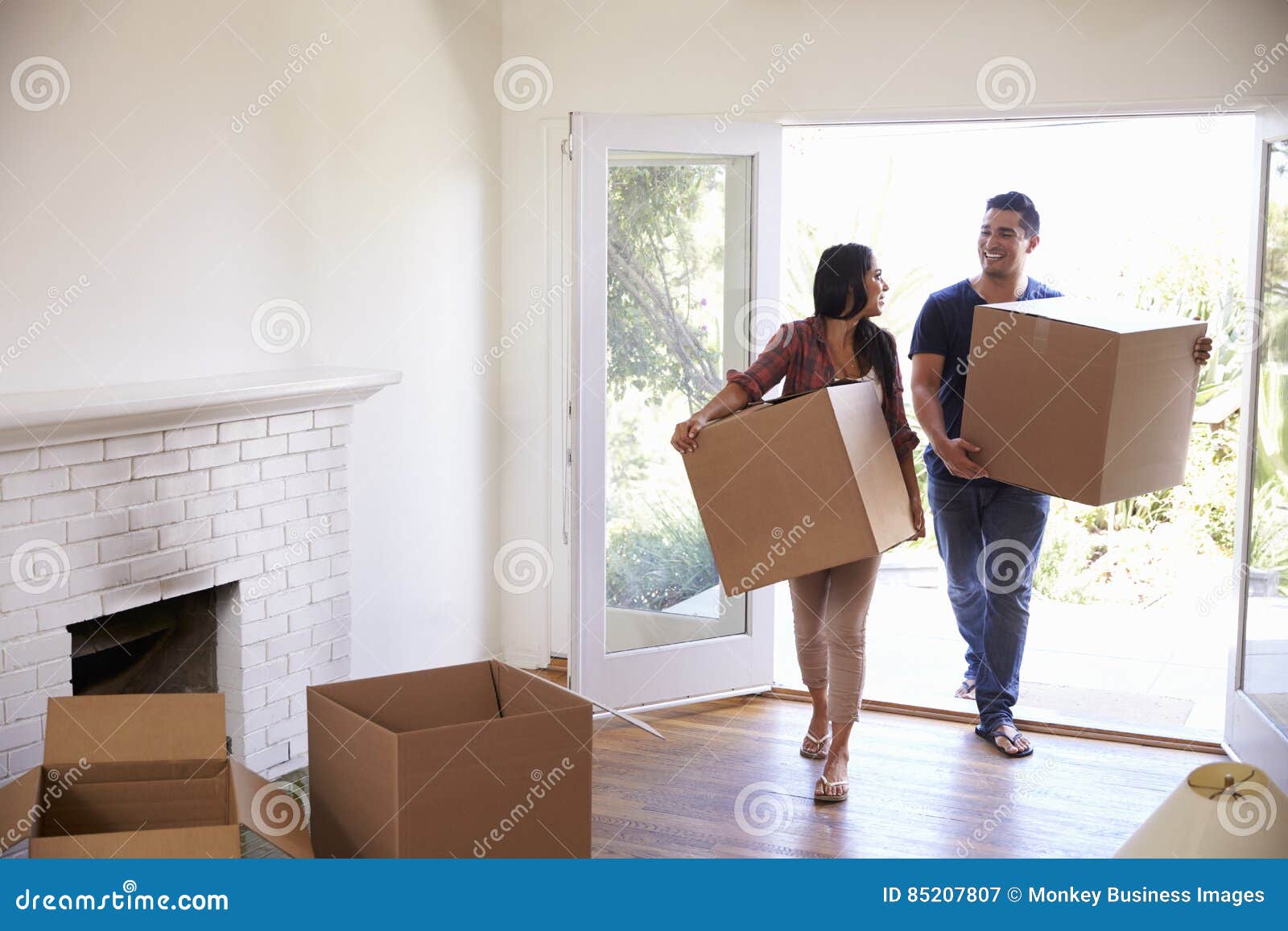 couple carrying boxes into new home on moving day
