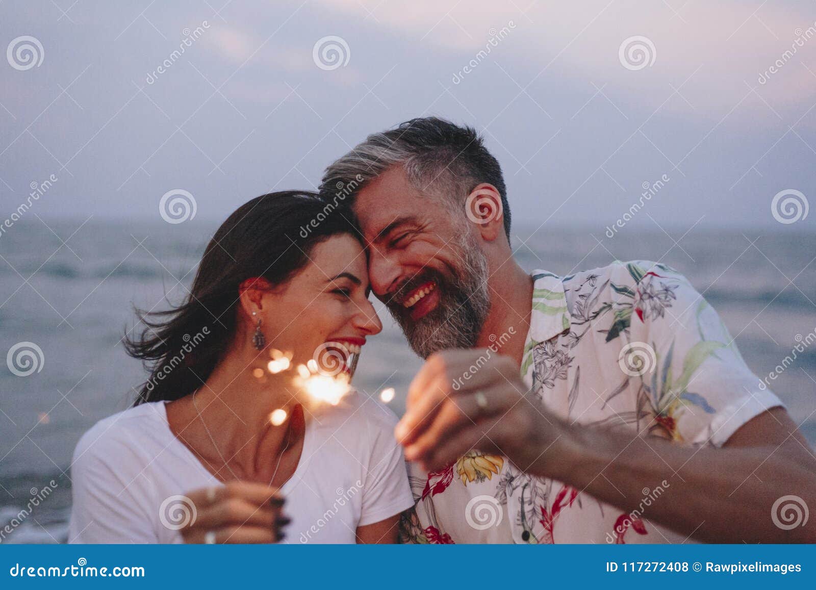 couple celebrating with sparklers at the beach
